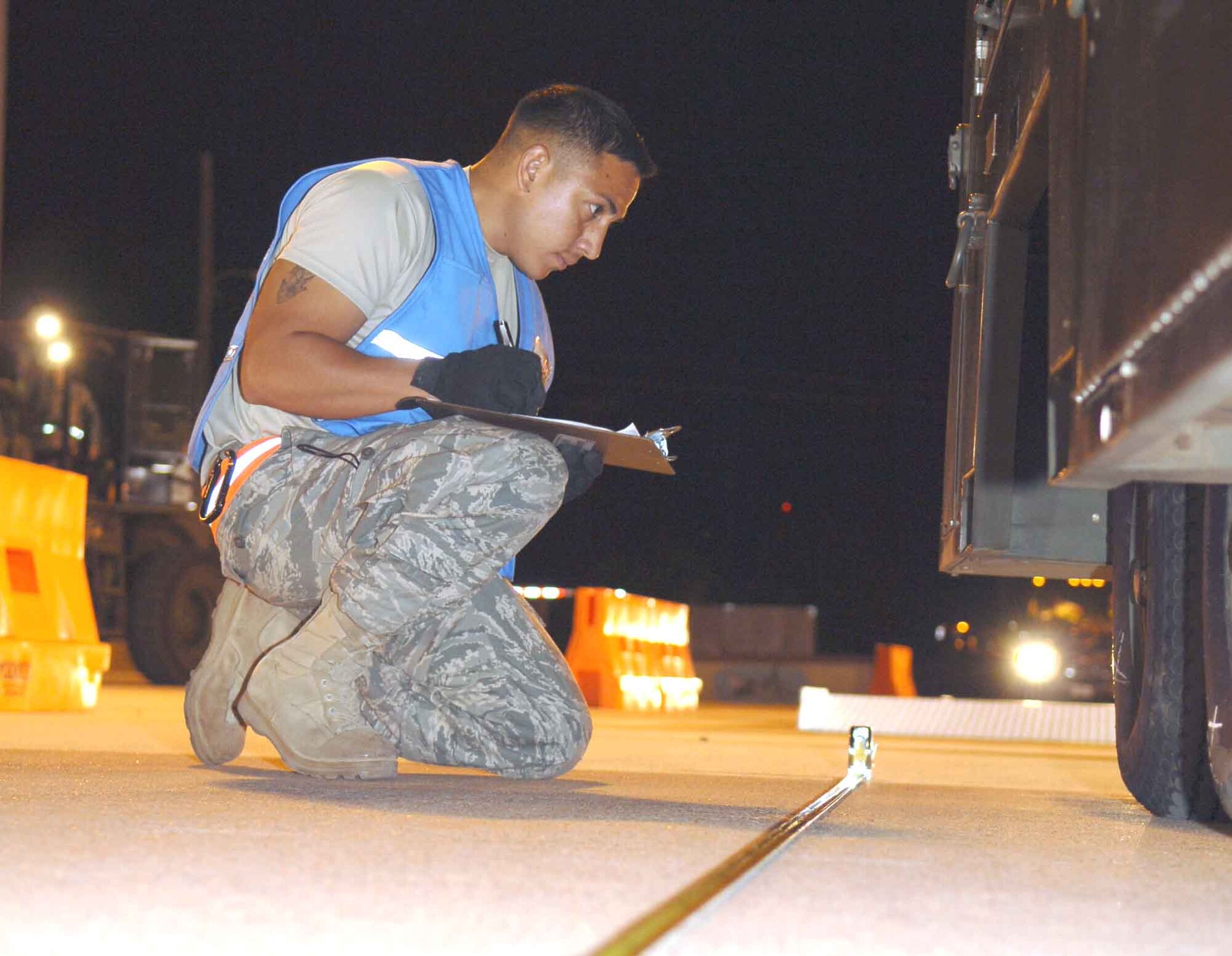 DYESS AIR FORCE BASE, Texas – Senior Airman Marcos Vasquez, 7th Logistics Readiness Squadron Air Terminal Operations, measures the distance between tires on a load of cargo being processed for simulated deployment in the cargo yard here Sept. 6. The weight of the cargo determines the specified distance for the tires, with an accepted two-inch range of deviation. (U.S. Air Force photo/Senior Airman Carolyn Viss)