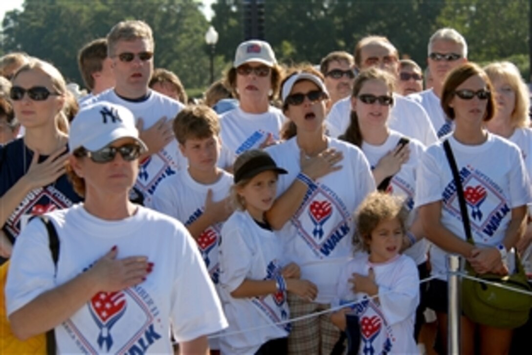 Participants in the 2008 National America Supports You Freedom walk listen as RoseAnn Lynch sings the national anthem at the Women in Military Service for America Memorial at Arlington National Cemetery, Va., Sept. 7, 2008. Thousands of people turned out for this year's Freedom Walk, which is a national tradition that calls on people to reflect on the lives lost on Sept. 11, 2001, remember those who responded, honor our veterans past and present and renew our commitment to freedom.
