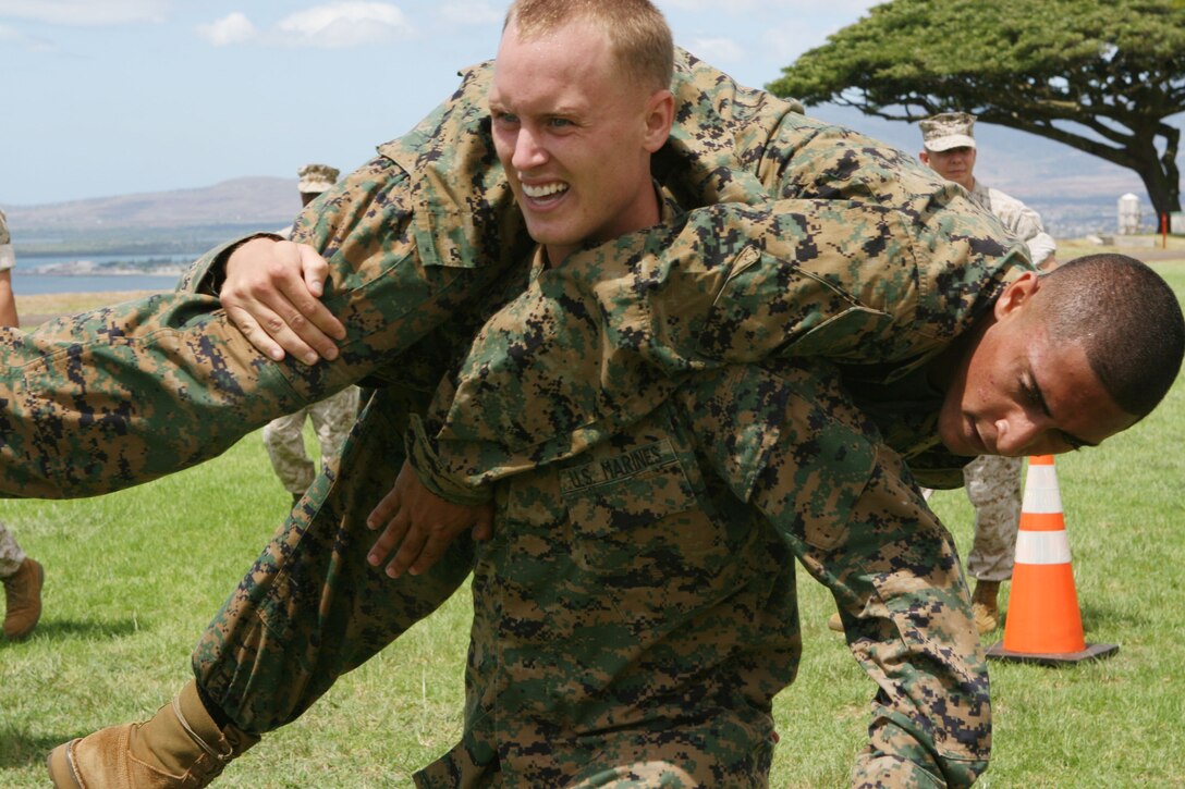 Cpl. Wade Mayhew, motor transportation operator with Headquarters and Service Battalion, U.S. Marine Corps Forces, Pacific, fireman carries Cpl. Andrew Robida, motor transportation operator with H&S Bn, MarForPac, during the Training and Education Command combat fitness test road show demonstration held at Bordelon Field Sept. 8.