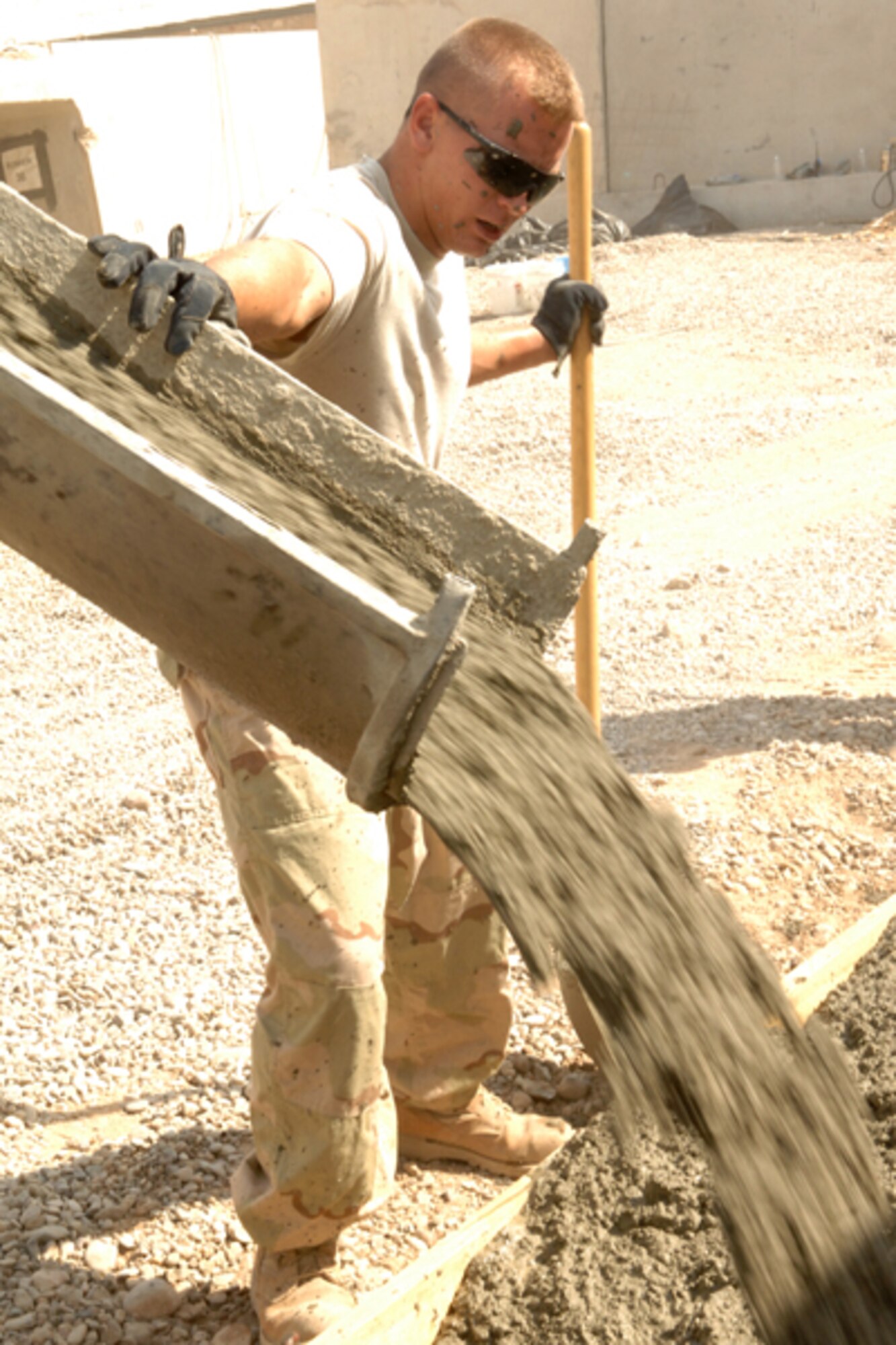 KIRKUK REGIONAL AIR BASE, Iraq -- Senior Airman Justin Fjeldsted, 506th Expeditionary Civil Engineer Squadron construction equipment operator, guides the pouring of cement at the passenger terminal.  Airman Fjeldsted and other Airmen from the 506 ECES have been working on the project for several weeks.  The project is replacing wooden walkways with concrete to and from the PAX terminal cleaning up the overall look as well as making it easier for personnel to travel on foot to and from the terminal.  Airman Fjeldsted is deployed from Tinker Air Force Base, Okla. and calls Tulsa, Okla. home.  (U.S. Air Force photo/ Senior Airman Randi Flaugh)
 