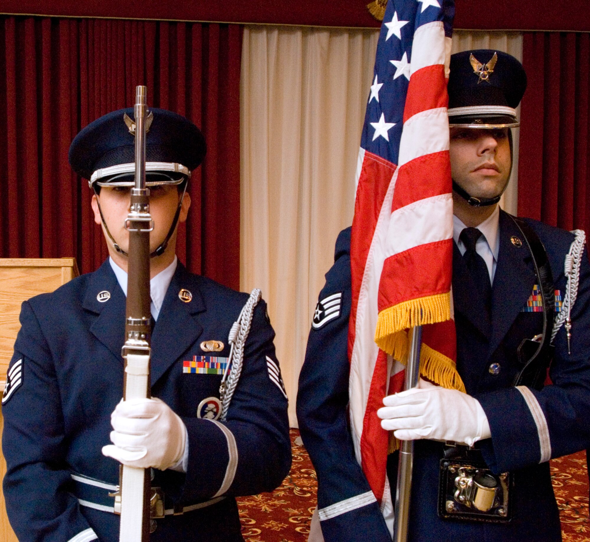 HANSCOM AFB, Mass. -- Staff Sgts. Jeremy Bridges and Philip Pelletier present the American flag to open the Senior Noncommissioned Officer Induction ceremony here, Sept. 4. Sergeant Bridges is assigned to the 66th Comptroller Squadron and is an Honor Guard volunteer; Sergeant Pelletier is assigned to the 66th Services Squadron and is in charge of Honor Guard operations.  (U.S. Air Force photo by Mark Wyatt)