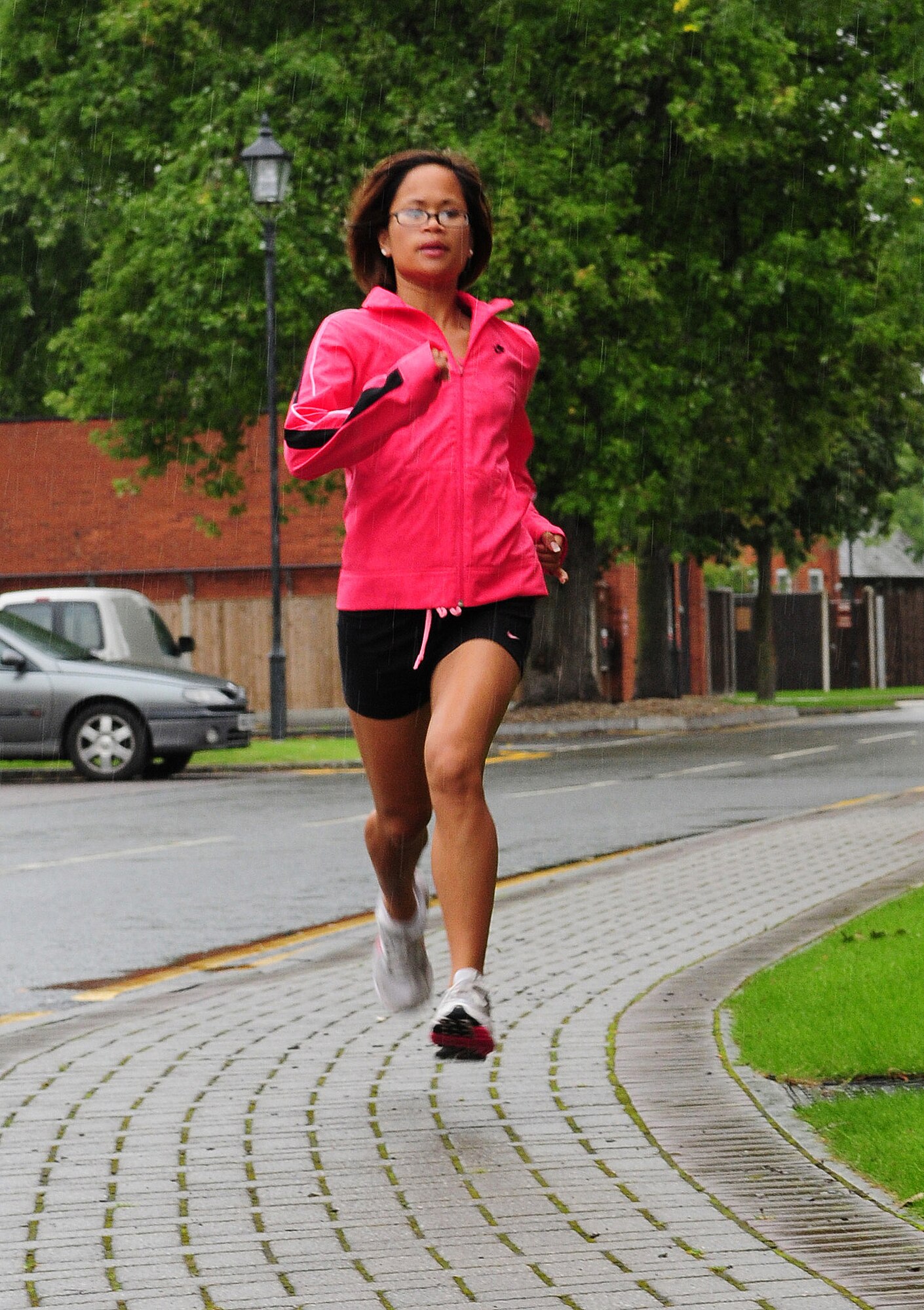 Trasy Rincan, a senior airman in the 100th Security Forces Squadron, runs sprints in the rain Sept. 5 at RAF Mildenhall. Senior Airman Rincan is one of six people selected by U.S. Air Forces in Europe to run in the Air Force Marathon half-marathon Sept. 20 at Wright-Patterson Air Force Base, Ohio. She ran RAF Mildenhall's half-marathon in 1:38.02 Aug. 29 and placed first out of the female participants. The Air Force Marathon half-marathon will be her third, when she runs it on her 22nd birthday. (U.S. Air Force photo by Karen Abeyasekere)