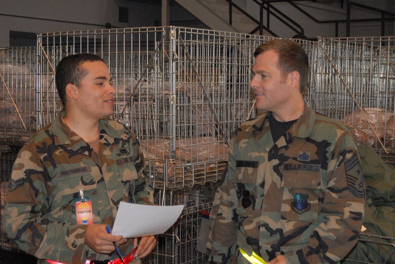 Chief Master Sgt. Douglas Ackerman, 43rd Airlift Wing Command Chief, talks with Airman 1st Class Raul Perez-Rodriguez, 3rd Aerial Port Squadron at a processing line at Bldg. 560 Wednesday. After serving as superintendent of 3rd APS, Chief Ackerman assumed 43rd AW command chief duties Aug. 28. (U.S. Air Force Photo by Staff Sgt. Jon LaDue)