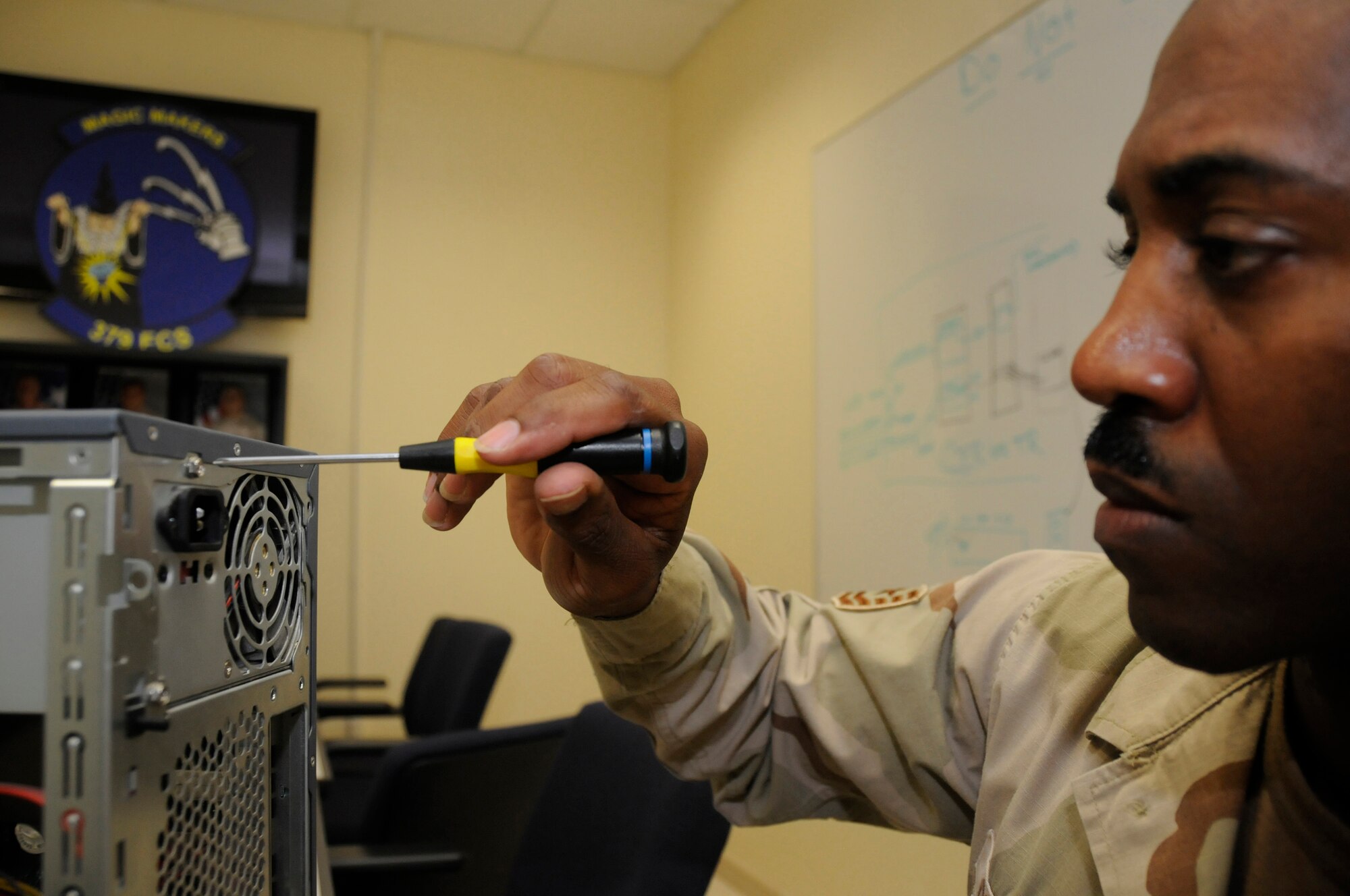 Tech. Sgt. Thomas Gipson, resource advisor for the 379th Expeditionary Communications Squadron, uses a screwdriver to install a power supply in a personal computer Sept. 7, 2008, at an undisclosed location in Southwest Asia. Sergeant Gipson and other resource advisors here approve and purchase communications devices for use in support of Operations Iraqi and Enduring Freedom and Joint Task Force-Horn of Africa. Sergeant Gipson, a native of Waycross, Ga., is deployed from Scott Air Force Base, Ill. (U.S. Air Force photo by Staff Sgt. Darnell T. Cannady/Released)