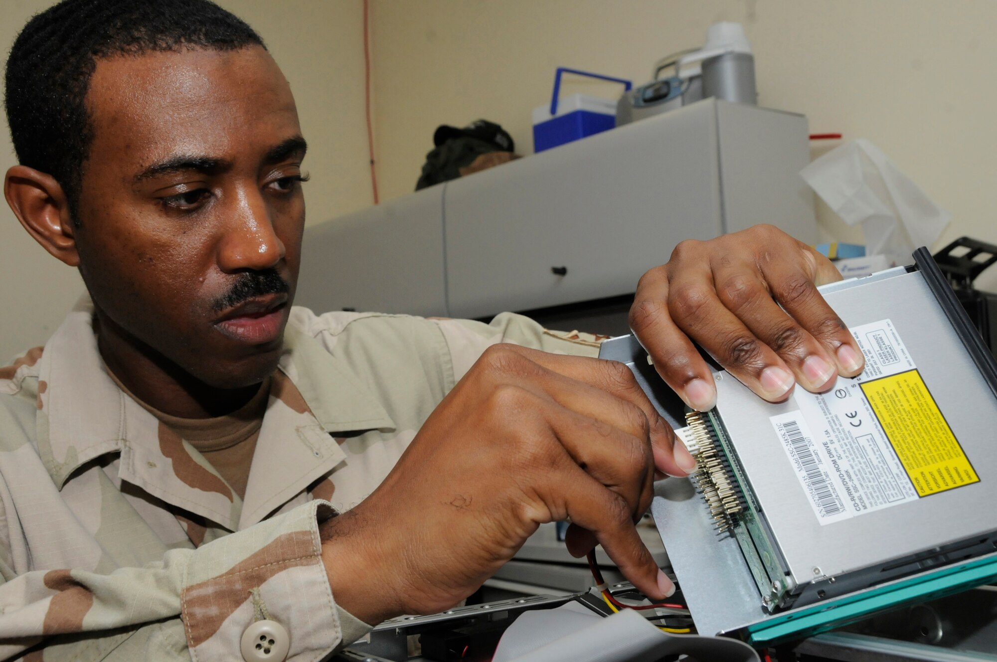 Tech. Sgt. Thomas Gipson, research advisor for the 379th Expeditionary Communications Squadron, installs a new DVD drive to a personal computer so it'll be able to read and record DVD discs Sept. 7, 2008, at an undisclosed location in Southwest Asia. Sergeant Gipson and other resource advisors here approve and purchase communications devices for use in support of Operations Iraqi and Enduring Freedom and Joint Task Force-Horn of Africa. Sergeant Gipson, a native of Waycross, Ga., is deployed from Scott Air Force Base, Ill. (U.S. Air Force photo by Staff Sgt. Darnell T. Cannady/Released)