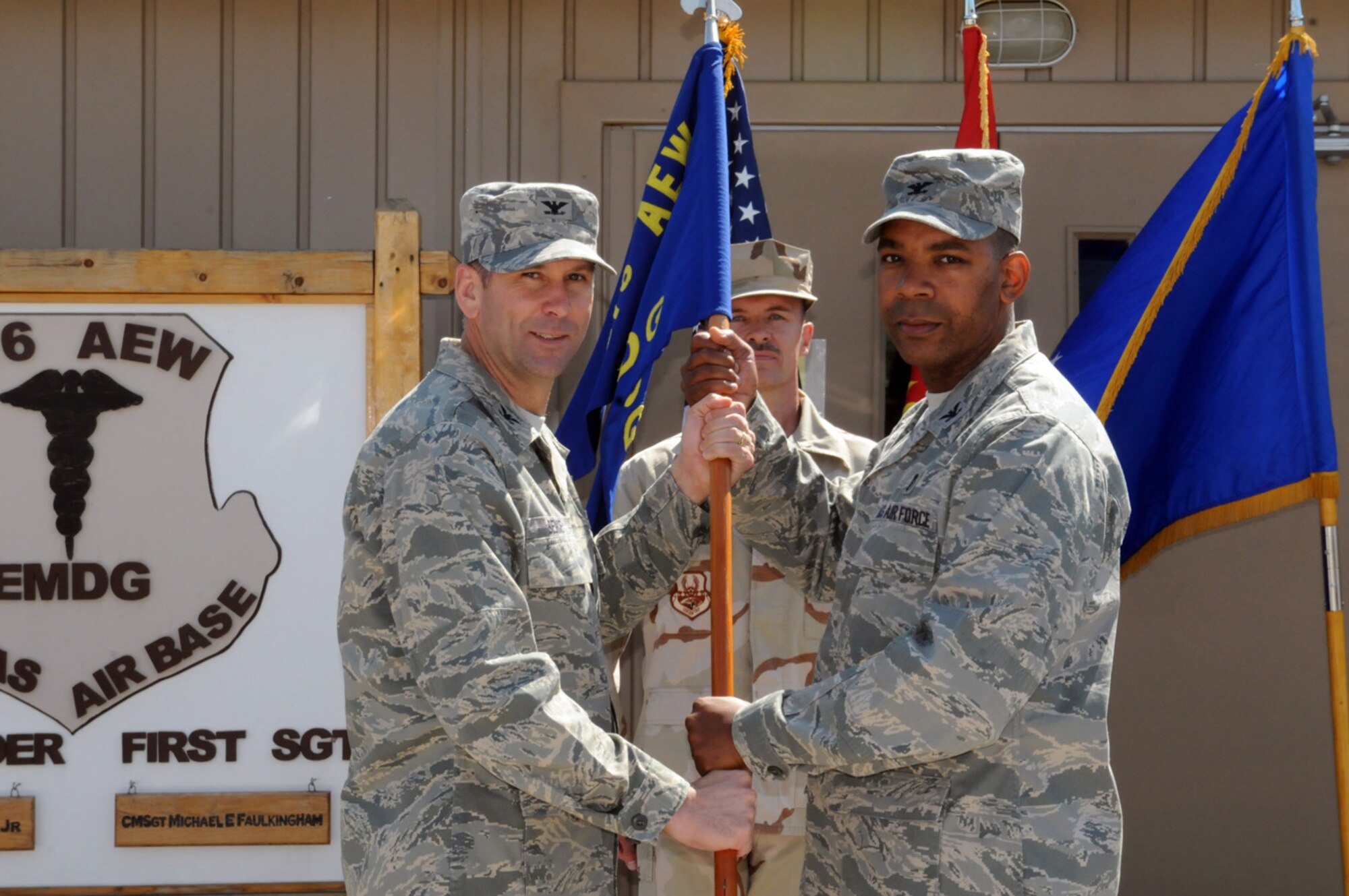 MANAS AIR BASE, KYRGYZ REPUBLIC -- Col. Roosevelt Allen (right) accepts the 376th Expeditionary Medical Group guidon from Col. Christopher Bence, 376th Air Expeditionary Wing commander, during a change of command ceremony here, Sept. 6. Colonel Allen assumed command of the 376th EMDG from Col. Thomas Grace, who returned to Barksdale Air Force Base, La., following a four month deployment to Manas AB. Colonel Allen is deployed from Minot AFB, N.D., where he commands the 5th Medical Group and directs base medical services. (Air Force photo / Senior Airman Ruth Holcomb)    
