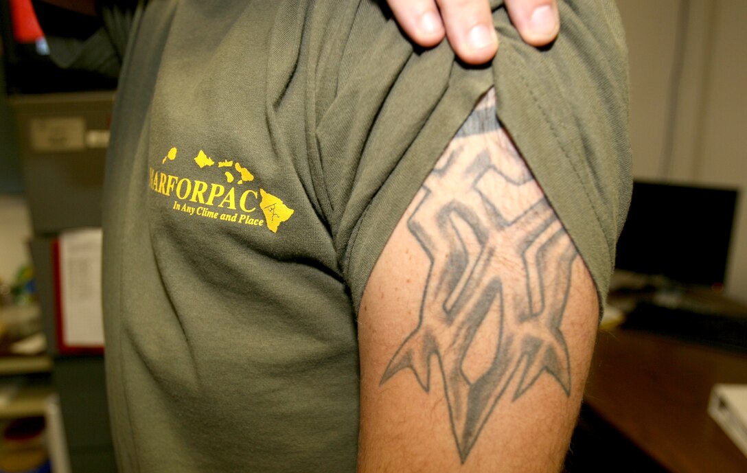 Sgt. Adam J. Brouillard, Marine Air Ground Task Force planner, G-3, MarForPac, displays his shoulder tattoo.  Per Marine Administrative Message 494/08, signed Sept. 4, Marines with tattoo sleeves are no longer authorized to serve as a recruiter or Marine Security Guard.  Tattoo sleeves are defined as a large tattoo or collection of smaller ones that covers or almost covers a person’s arm or leg.