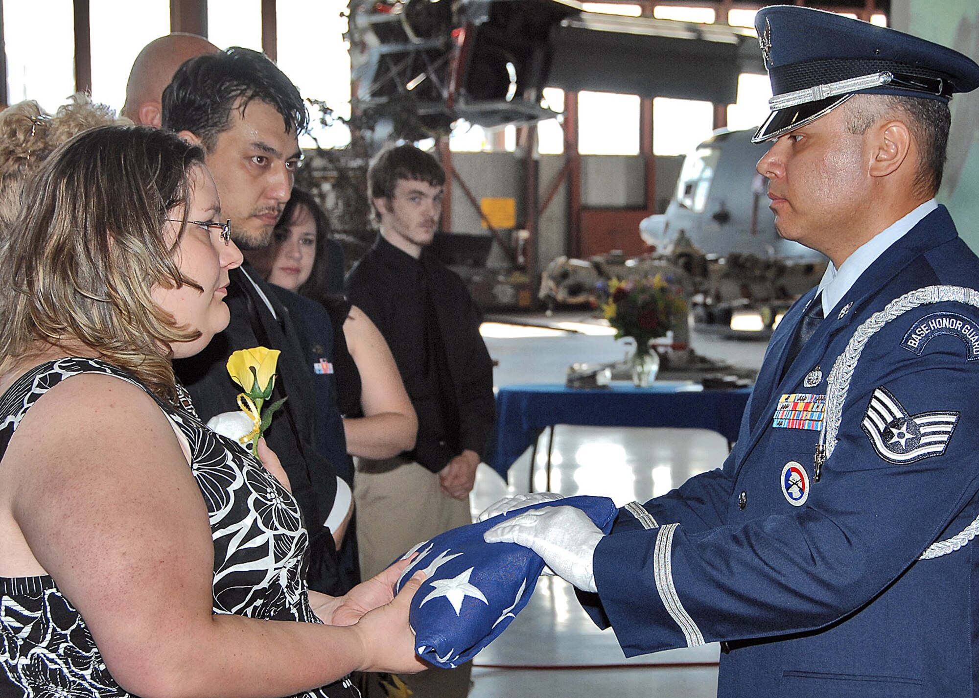 A memorial service for Staff Sgt. Anthony Slentz, 58th Special Operations Wing, was held on Aug. 18. He died on Aug. 14 at University of New Mexico Hospital after an extended battle with cancer. His widow, Tara, accepts a flag from Staff Sgt. Nelson Romero, Kirtland AFB Honor Guard, during the service at the 58th SOW. U.S. Air Force photo by Todd Berenger
