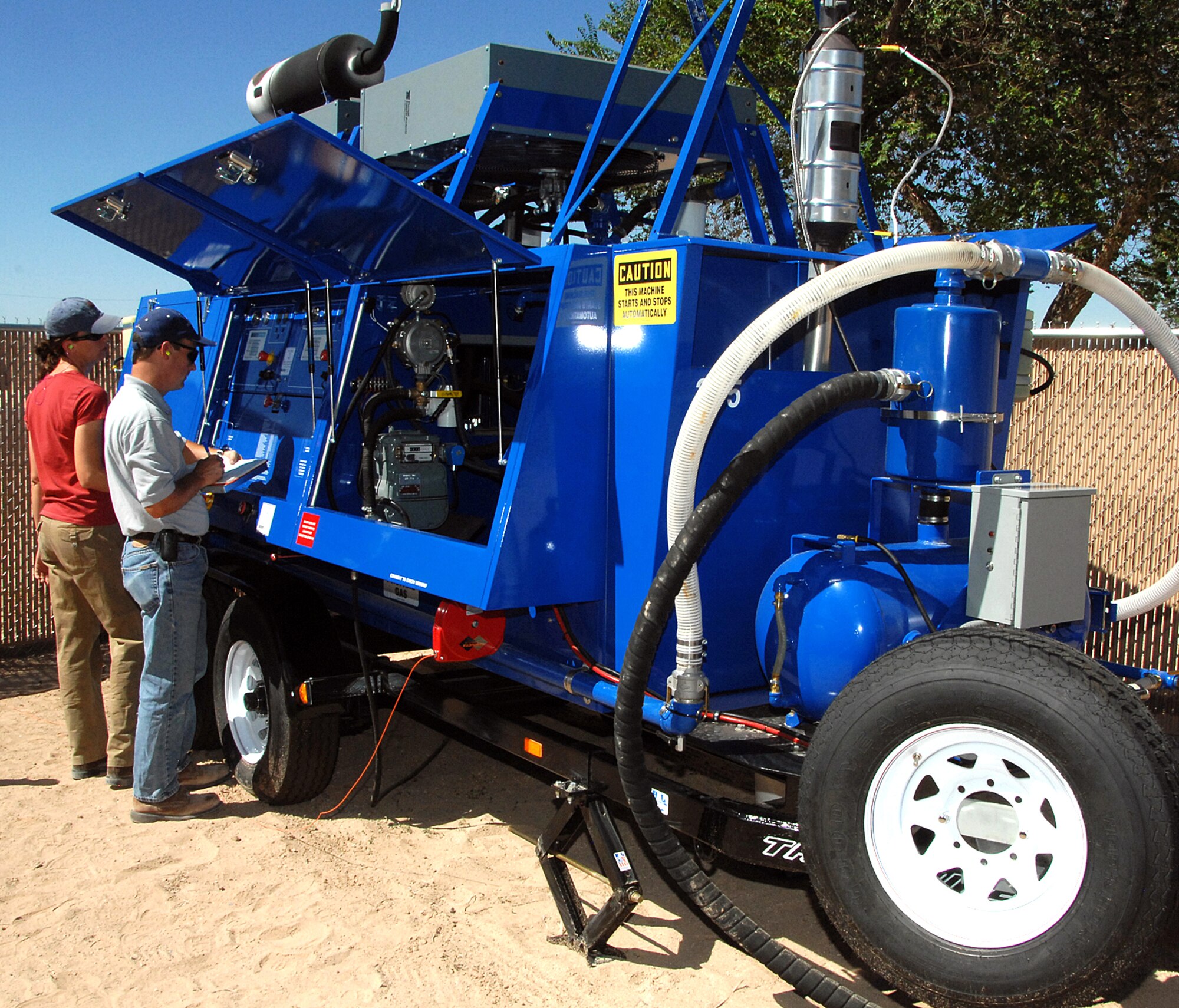 CH2MHill employees Jeffrey Minchak and Merideth Brislen monitor the progress of fuel recovery at a pump sight. The second soil vapor extraction unit added to the Kirtland AFB, effort at the monitoring point where fuel was discovered first on the water table in 2007. The new apparatus will operate 24 hours a day, 7 days a week to remove up to 300 gallons of petroleum product daily. U.S. Air Force photo by Todd Berenger
