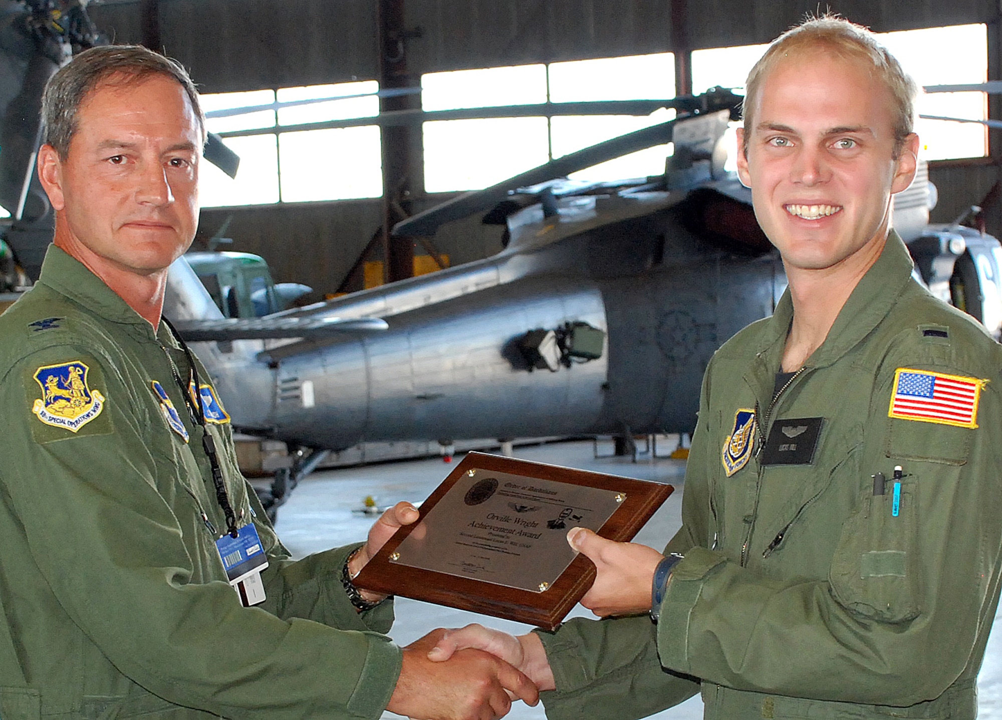 Col. James Marsh, 58th Special Operations Wing vice commander, presents 1st Lt. Lucas Will, a 512th Rescue Squadron student pilot, with the prestigious Daedalian Foundation Orville Wright Achievement Award in a ceremony in Hangar 1001 Aug. 19. His citation states, ?Lieutenant Willl?s performance in the Specialized Undergraduate Pilot Training-Helicopter was at a level well above his peers.? He also excelled academically and won several awards. U.S. Air Force photo by Dennis Carlson
