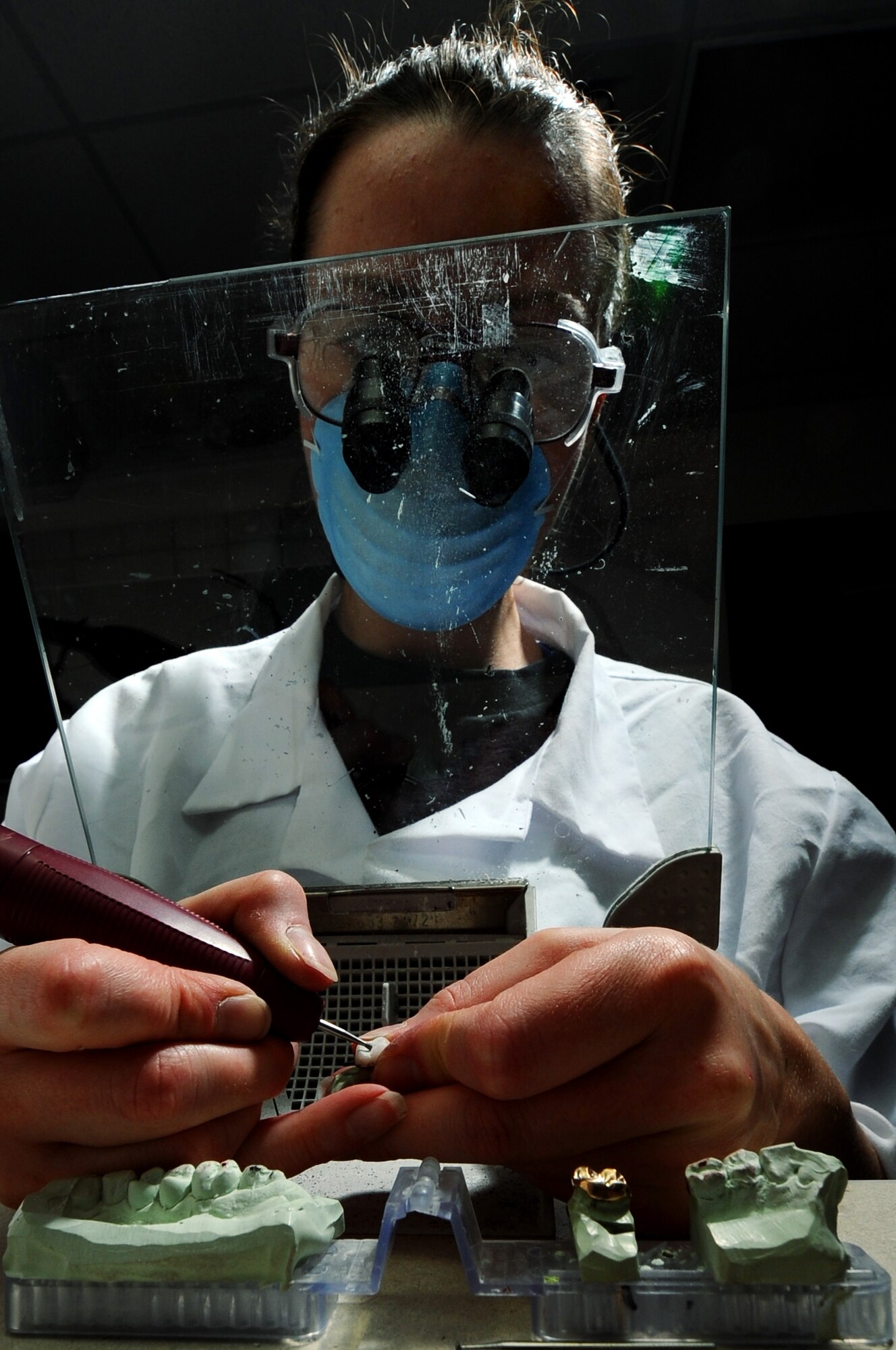 Staff Sgt. Amy Cadavero shapes a porcelain crown using a dental drill with a diamond bur drill bit Sep. 9, 2008, at Eielson Air Force Base, Alaska. Once Sergeant Cadavero receives the impressions made from the patient teeth she will then make it into a cast mold to start shaping the crown so it will fit comfortably in the patients' mouth, this process can take up to a week to finish. She is a dental lab technician assigned to the 354th Medical Operations Squadron.  (U.S. Air Force photo/Airman 1st Class Jonathan Snyder)