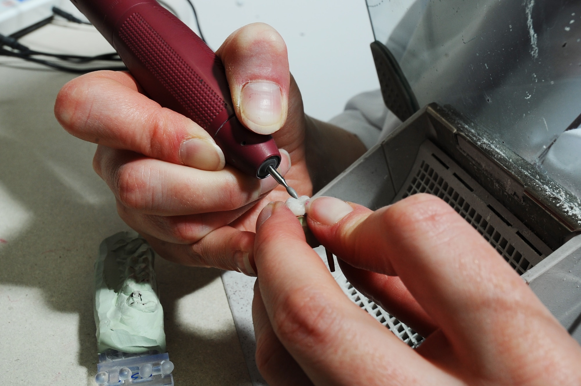 Staff Sgt. Amy Cadavero shapes a porcelain crown using a dental drill with a diamond bur drill bit Sep. 9, 2008, at Eielson Air Force Base, Alaska. Once Sergeant Cadavero receives the impressions made from the patient teeth she will then make it into a cast mold to start shaping the crown so it will fit comfortably in the patients' mouth, this process can take up to a week to finish. She is a dental lab technician assigned to the 354th Medical Operations Squadron.  (U.S. Air Force photo/Airman 1st Class Jonathan Snyder)