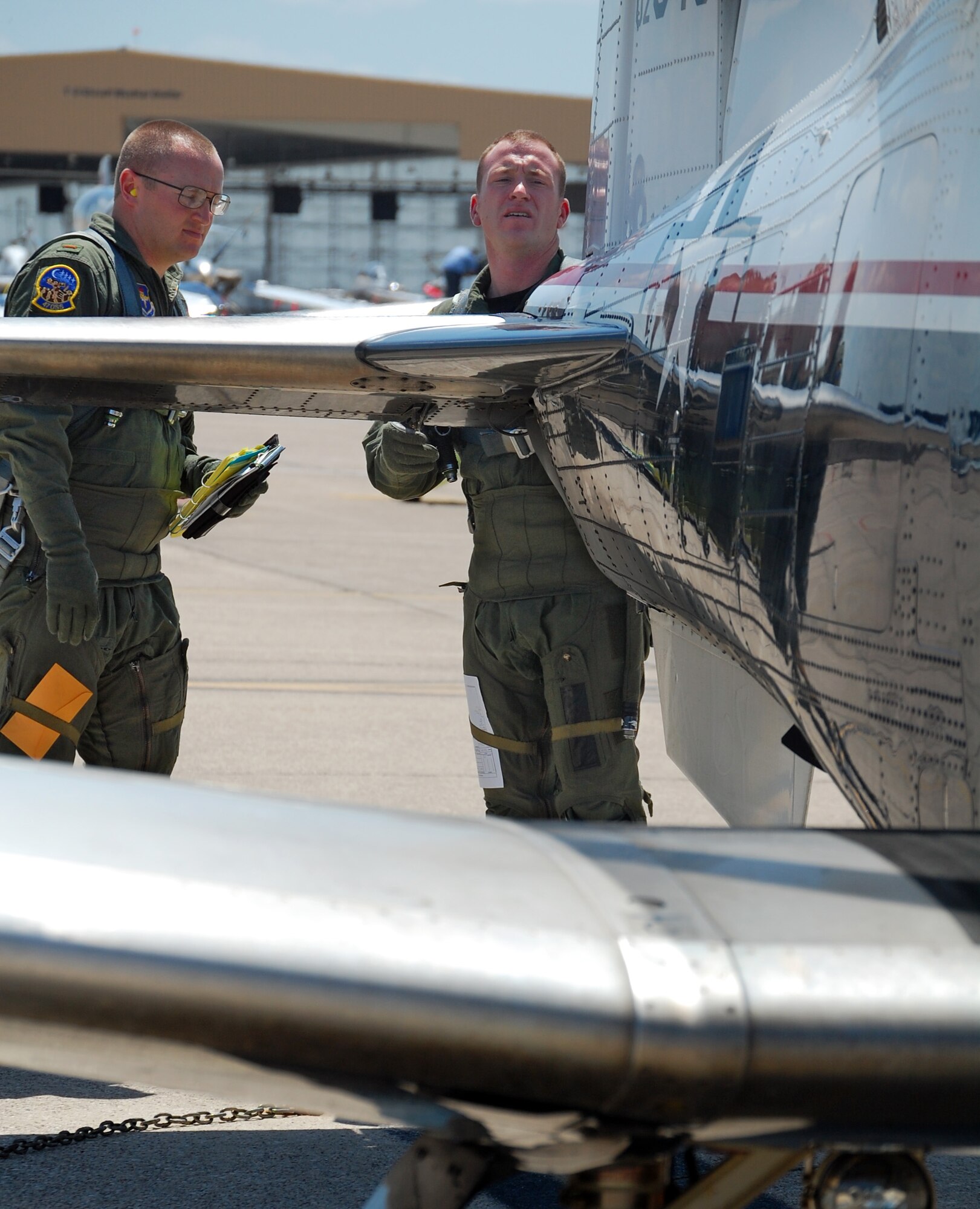 LAUGHLIN AIR FORCE BASE, Texas – 1st Lt. Scott Thompson, 85th Flying Training Squadron instructor pilot,  gives 2nd Lt. William Cary, Specialized Undergraduate Pilot Training student, precise instructions on how to conduct pre-flight inspection of the air frame before his “dollar ride” in the T-6 Texan II here Sept. 9. A dollar ride is the student’s first ride in the aircraft with an instructor pilot during their training here. (U.S. Air Force photo by Airman 1st Class Sara Csurilla)