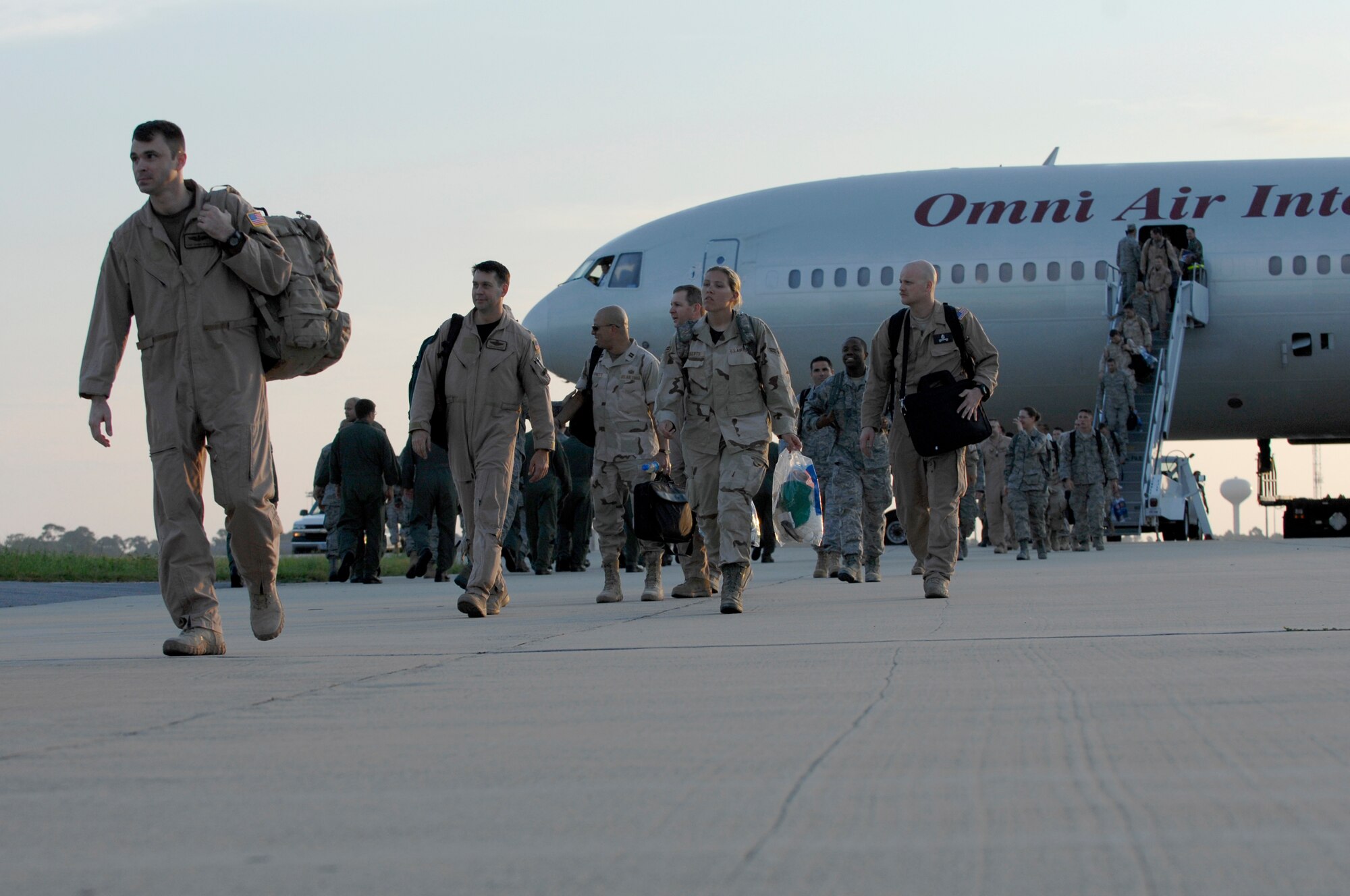 Air Commandos assigned to the 1st Special Operations Wing and associate units exit their plane and walk across the tarmac to reunite with family members Sept. 6; Hurlburt Field, Fla. Operation Homecoming allows family, friends, and co-workers to reunite with their loved ones as soon as they land after a deployment.  (U.S. Air Force photo/ Senior Airman Julianne Showalter)(RELEASED)