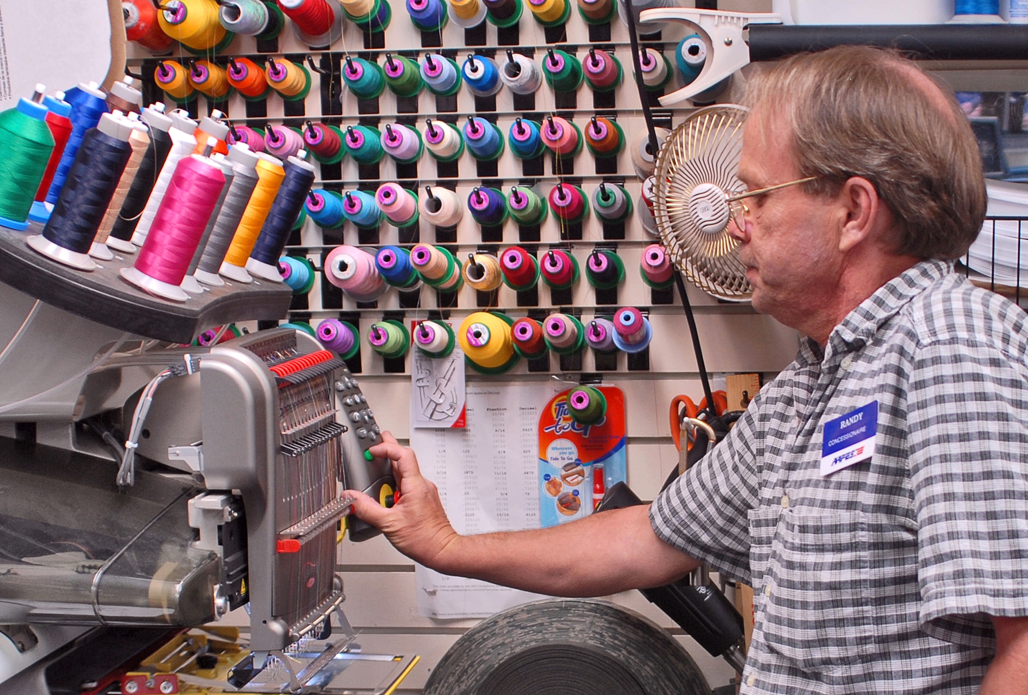 Randy Shankles operates one of the computerized embroidery machines which can produce uniform name tapes.