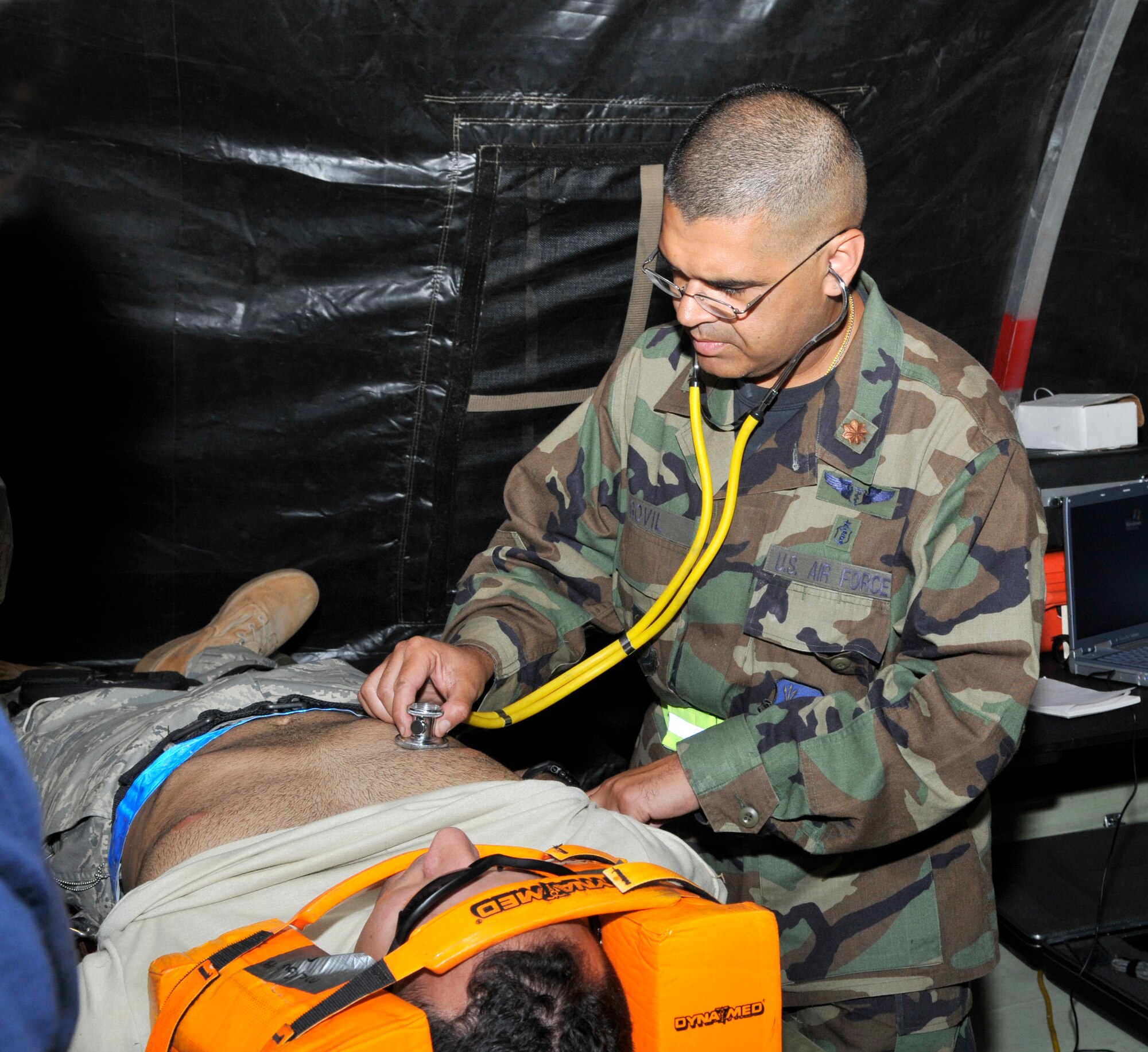 Maj. Niraj Govil, 305th Medical Group, performs an initial medical assessment on his patient, Staff Sgt. David Bernal, 514th Civil Engineer Squadron, during a mobility exercise here Sept. 8. Sergeant Bernal was injured in a simulated vehicle accident as one of the scenarios used in the exercise to help prepare McGuire personnel for next year’s Operational Readiness Inspection. (U.S. Air Force photo/Kenn Mann)