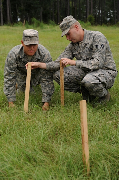 MOODY AIR FORCE BASE, Ga. – Senior Airman Hendrikus Van Zoest instructs Airman 1st Class Mark Baldengro, both 23rd Civil Engineer Squadron engineer specialists, on placing a batter board on stakes during training here Aug. 21. Batter boards are horizontal boards that are attached level to stakes to mark  the boundary of a construction area and establish the levels and building line. (U.S. Air Force photo by Senior Airman Gina Chiaverotti) 
