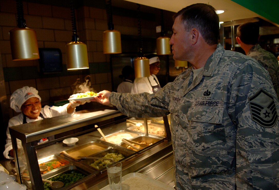 Ms. Chaluai Miles, 1st Force Support Squadron food service worker, serves lunch to Master Sgt. Michael Woodward, Air Combat Command , at the Eagle Room Dining Facility here on Aug. 27. (U.S. Air Force photo/Tech. Sgt. Levi Collins) 