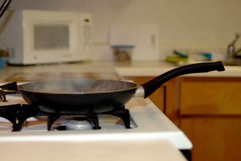 LANGLEY AIR FORCE BASE,Va -- Airman 1st Class Jonathan Koob shows the danger of leaving the kitchen while cooking Sept. 9. If smoldering food is left alone long enough it is likely that it will catch fire.  It's a good idea is to keep a lid nearby when cooking so if a small grease fire starts, flames can be smothered by sliding the lid over the pan. (U.S. Air Force photo/Airman 1st Class Jonathan Koob)