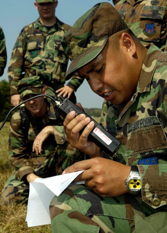 Tech Sgt. Kenneth Bernardo, a member of Blackhawk Team, calls in a scenario using a radio as part of the obstacle course. The purpose of this excercise is to be able to establish radio communications with the command post.  Other stations of training included disassembling M-16 rifles, high crawl  with gas masks, low crawl, building defensive fighting posiiton barriers, grenade throwing, tactical movements and unexploded ordnance detection Sept. 4. (USAF photo by Senior Airman Renea Kleckner)