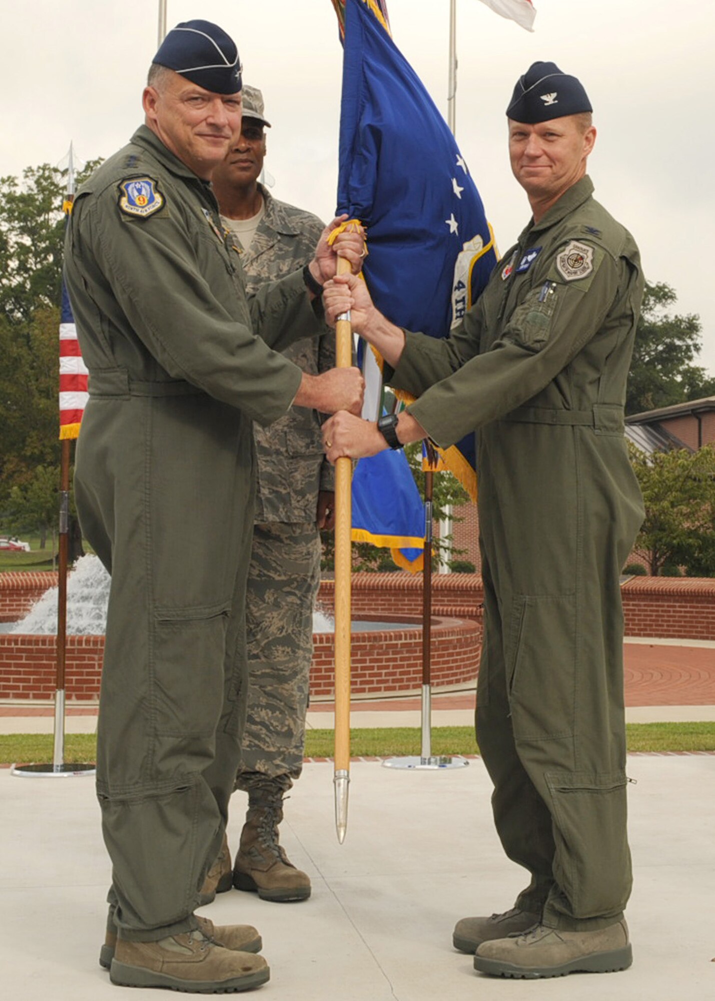 SEYMOUR JOHNSON AIR FORCE BASE, N.C. -- Lt. Gen. Gary North (left), 9th Air Force commander, passes the guidon to Col. Mark Kelly, during the 4th Fighter Wing change of command ceremony here Sept. 9. Colonel Kelly assumes command after returning from a recent deployment as the vice commander of the 455th Air Expeditionary Wing at Bagram Airfield, Afghanistan. (U.S. Air Force photo by Airman 1st Class Ciara Wymbs)