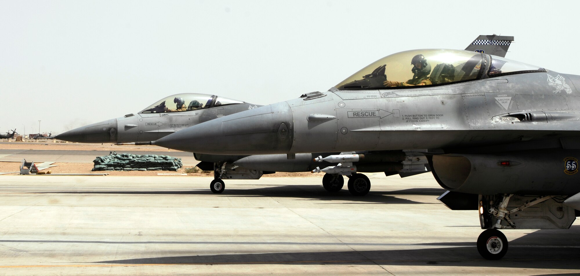 JOINT BASE BALAD, Iraq -- Two F-16 Fighting Falcons flown by 77th Expeditionary Fighter Squadron pilots wait to be de-armed here after flying sorties in support of Operation Iraqi Freedom Sept. 2. Aircraft must de-arm before taxiing into a hardened shelter. The F-16s are deployed from Shaw Air Force Base, S.C. (U.S. Air Force photo/Airman 1st Class Jason Epley)