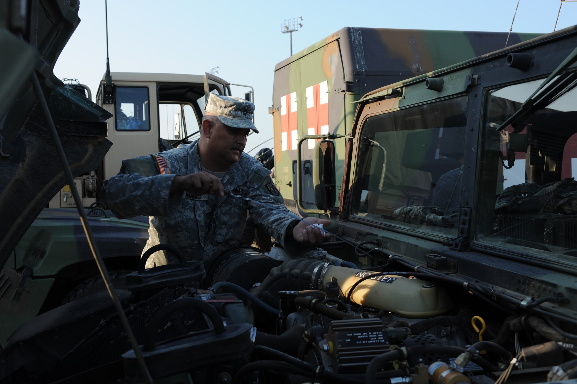 DYESS AIR FORCE BASE, Texas - Sergeant First Class Jacob Madrid, 1200th Infantry Battalion New Mexico Army National Guard, checks the oil in his HM-V in the Dyess AFB fitness center parking lot, Sept.  2. The soldiers must complete preventive maintenance checks  and service on their vehicle which includes checking the oil, tire pressure, leaks and fluid levels. Dyess Airmen are ready and willing to assist and support sister service members whether active duty, guard or reserve. (U.S. Air Force photo/ Senior Airman Courtney Richardson)