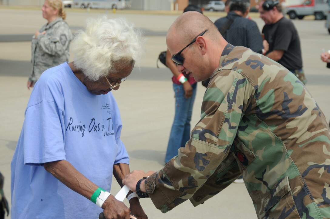 A Kentucky Air National Guard member places an identification wristband around the wrist of an elderly Gulf Coast resident after the woman arrived in Louisville, Ky., aboard a contract airlined Aug. 31. Nearly 1,500 Lousiana residents stayed in Kentucky after being dispaced by Hurricane Gustav. (Photo by Tech. Sgt. Phil Speck, Kentucky Air National Guard.)