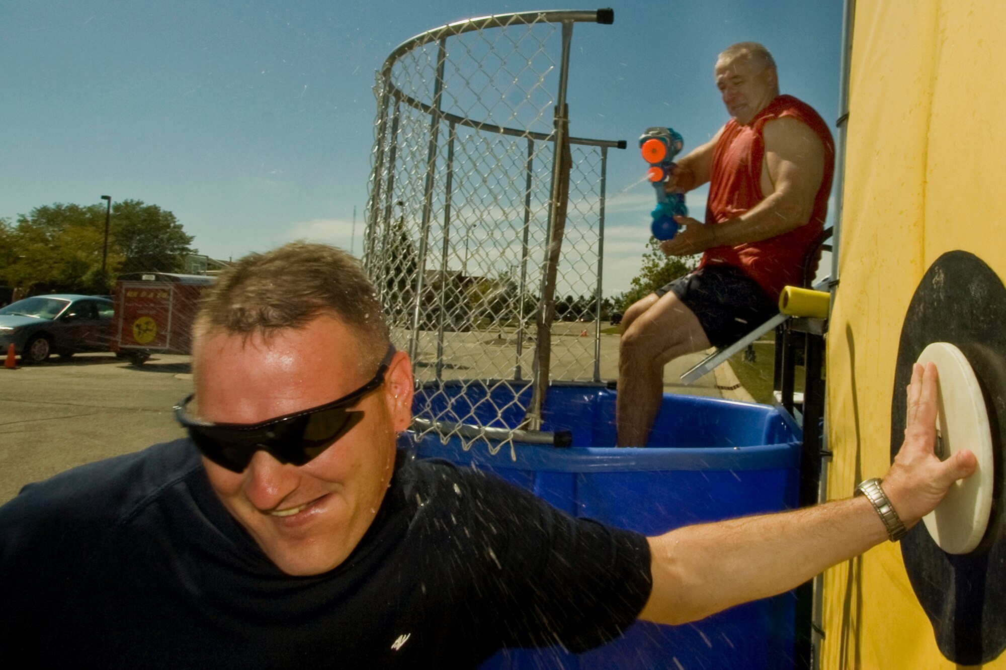 GRISSOM AIR RESERVE BASE, Ind., -- Senior Master Sgt. Darin Daugherty, 434th Aircraft Maintenance Squadron flight chief,  sneaks in for a manual assist in dunking his boss Chief Master Jeff Mercier, 434th Aircraft Maintenance Squadron maintenance manager, during the family day picnic. (U.S. Air Force photo/Tech. Sgt. Patrick Kuminecz)