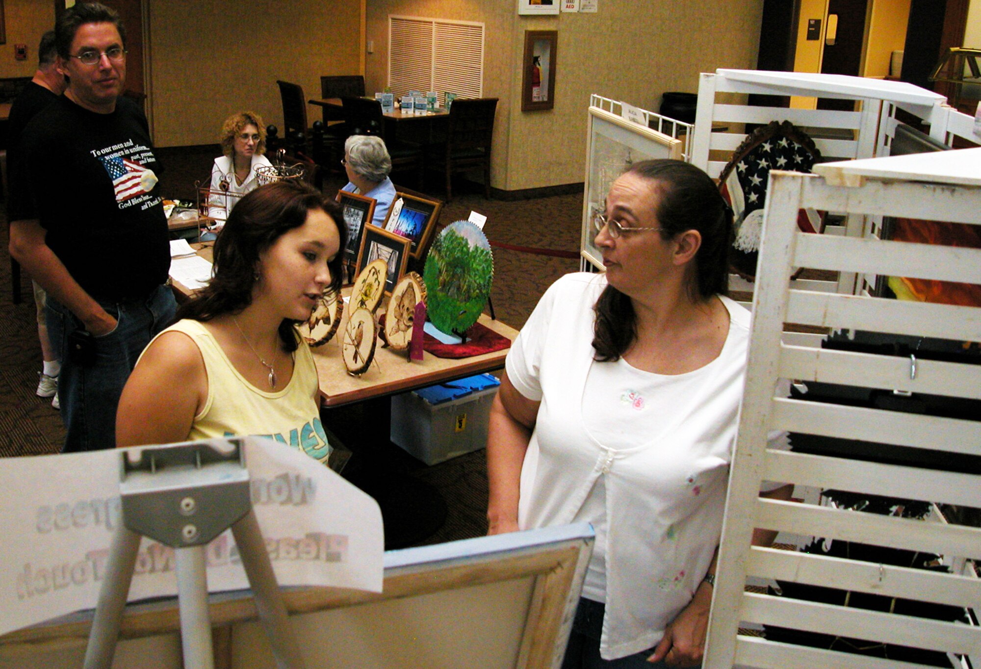 GRISSOM AIR RESERVE BASE, Ind., -- Monica Hunter, left, and Cathy Gordon, look at artwork by Dan Harshman, far left, 434th Communications Squadron, that was on display during the annual family day picnic. (U.S. Air Force photo/Staff Sgt. Chris Bolen)