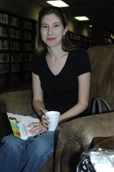MINOT AIR FORCE BASE, N.D. -- Lisa Bibey, wife of Airman Nick Bibey, 791st Missile Squadron, enjoys a cup of freshly brewed coffee from the newly opened self-serve coffee bar in the base library. Having recently arrived from Florida, Mrs. Bibey said she considers the library a great place to get a warm cup of coffee when it’s cold. (U.S. Air Force photo by 2nd Lt. Kidron B. Vestal)