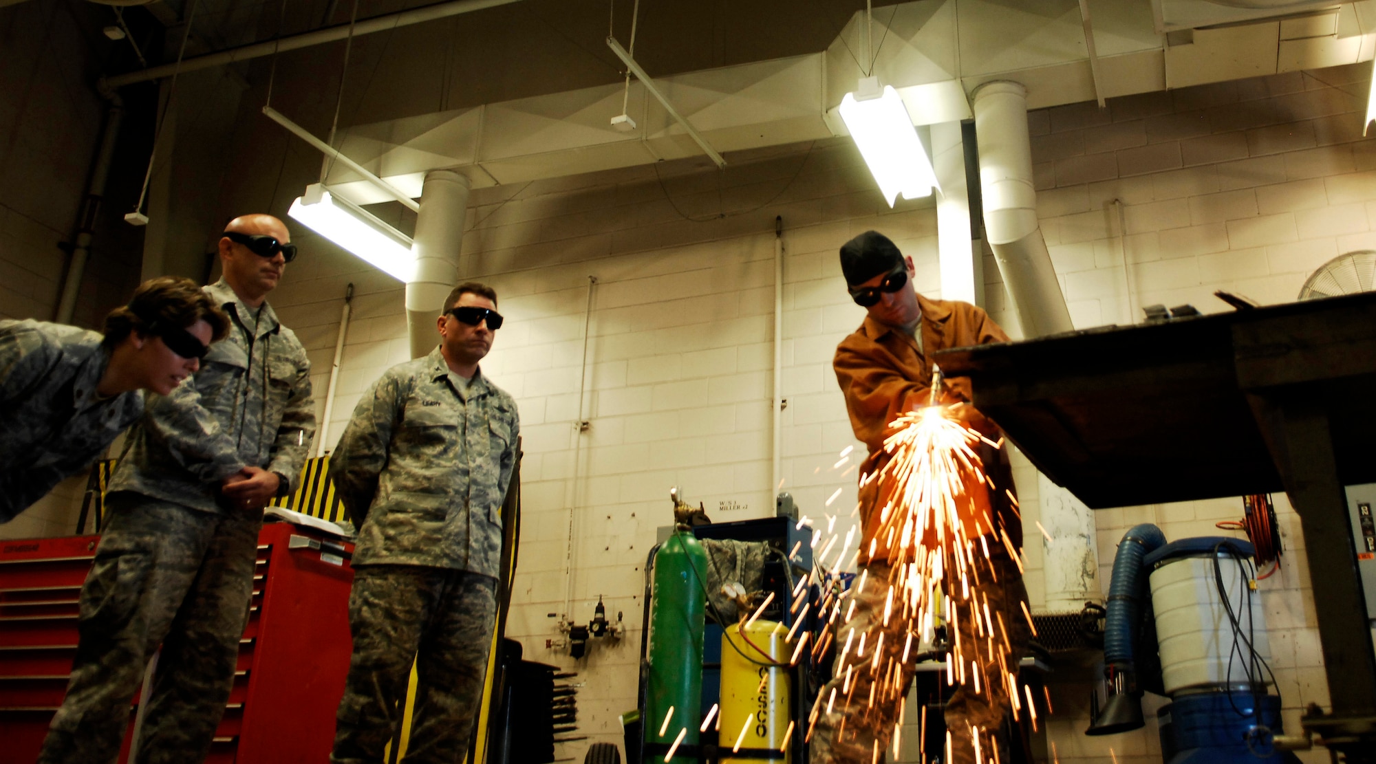 CANNON AIR FORCE BASE, N.M. - Staff Sgt. Justin Darland, 27th Special Operations Equipment Maintenance Squadron, demonstrates the squadron's new oxy-acetylene torch Sept. 5 to (left to right) Maj. Michelle Estes, 27th SOEMS commander, 27th Special Operations Wing Command Chief Master Sgt. Daniel Fischer and Col. Timothy Leahy, 27th SOW commander. The demonstration was given to show the differences between the squadron's current and previous torches. (U.S. Air Force photo/Airman 1st Class Evelyn Chavez)