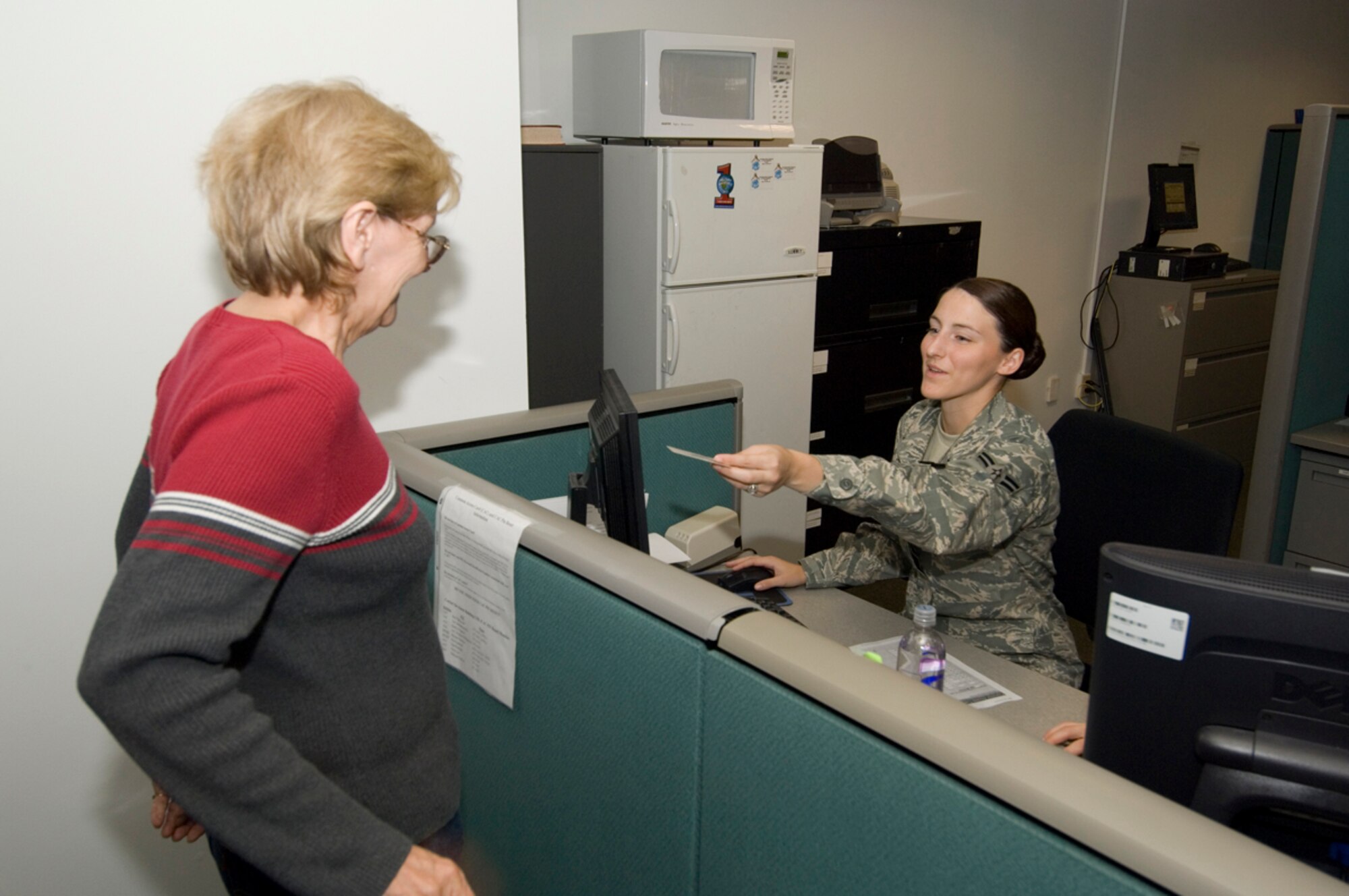 HANSCOM AFB, Mass. -- Airman 1st Class Brittni Linderman, 66th Mission Support Squadron, Military Personnel Flight customer service technician, assists a customer from the MPF's new customer service desk, Sept. 9. Recently, almost all MPF Airmen were relocated to the first floor of the Brown Building, building 1305, and a number of improvements were implemented to better meet customer needs. (U.S. Air Force photo by Rick Berry)