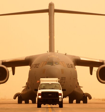 JOINT BASE BALAD, Iraq -- A C-17 Globemaster guided by a Transient Alert truck taxies toward a parking ramp here after landing during a sandstorm Sept. 8. The C-17 is deployed from Charleston Air Force Base, S.C. (U.S. Air Force photo/Airman 1st Class Jason Epley)