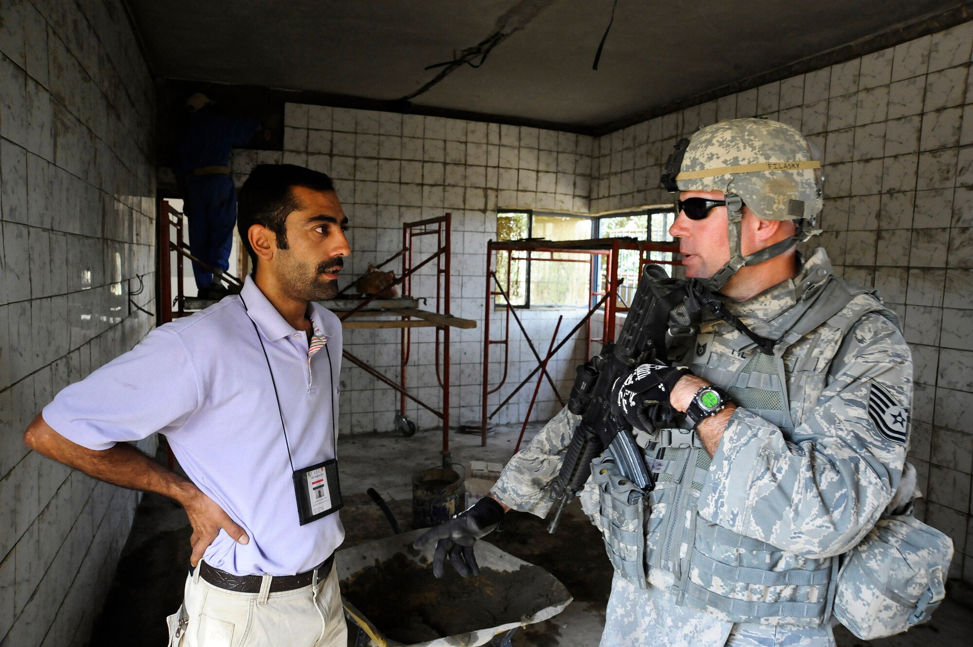 Tech. Sgt. Jason Filasky talks with a contractor about the tile being used for a battled damaged home in the city of Hawr Rajab, Iraq, Aug. 27. Sergeant Filasky is a contracting representative with the 557th Expeditionary RED HORSE Squadron. (U.S. Air Force photo/Staff Sgt. Paul Villanueva II)