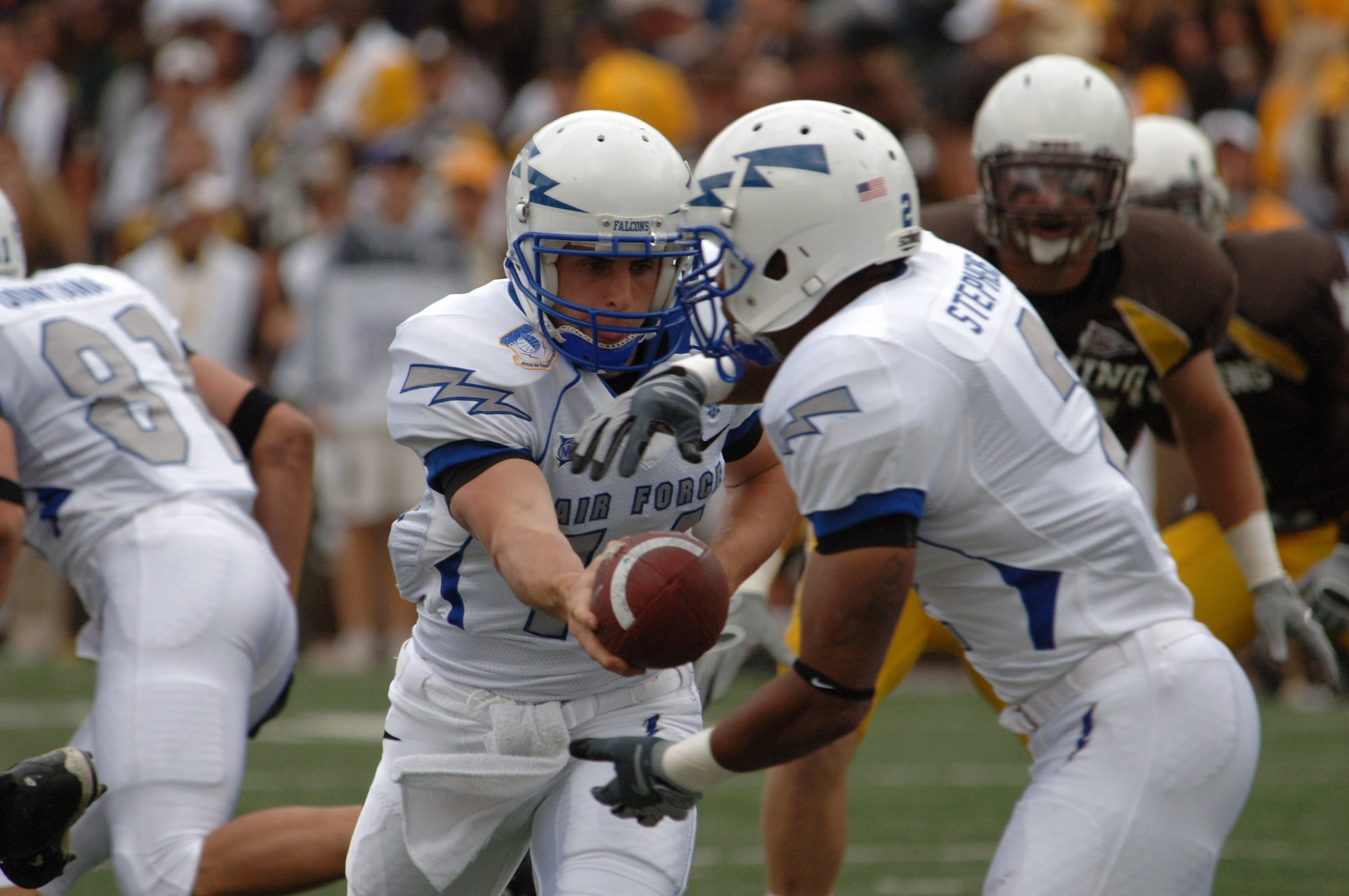 U.S. Air Force Academy quarterback Shea Smith hands off to tailback Savier Stephens Sept. 6 in Laramie, Wyo. Smith recorded 43 yards rushing and Stephens another 37 yards, and the Falcons offense ground out 261 yards on the ground in a 23-3 win over Wyoming. (U.S. Air Force photo/John Van Winkle) 
