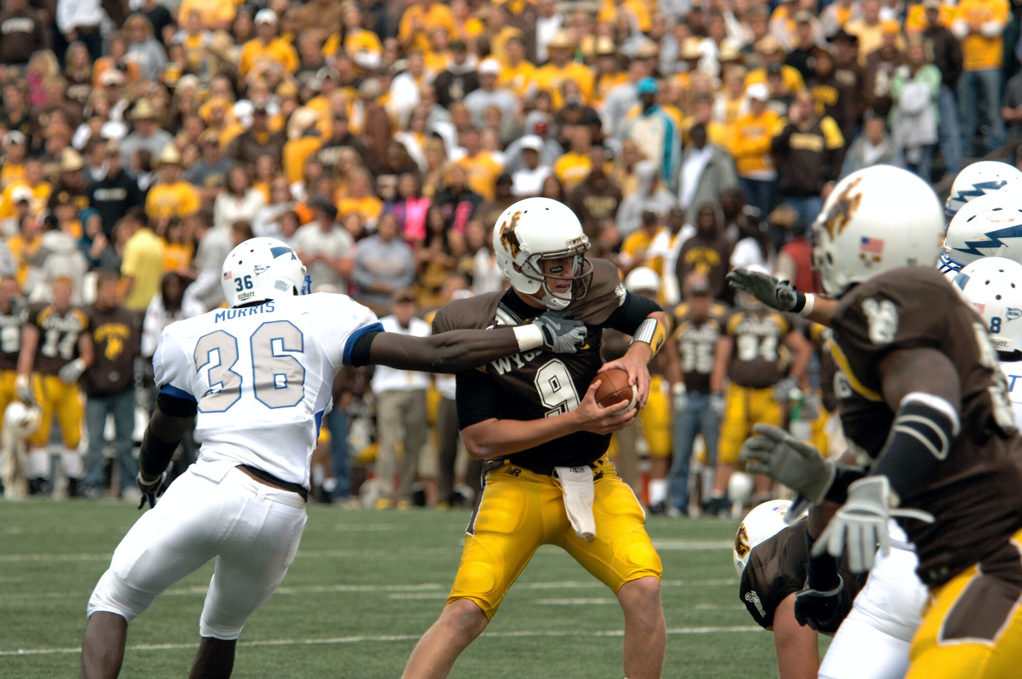 U.S. Air Force Academy linebacker Andre Morris makes sure Wyoming quarterback Dax Crum doesn't escape his grasp and tackles Crum for a four-yard loss Sept. 6 in Laramie, Wyo. Falcon defenders recorded four sacks, five tackles for losses, forced three fumbbles and held Wyoming to only 216 yards total offense. The Falcons' defense has only allowed 10 points this season. (U.S. Air Force photo/John Van Winkle) 
