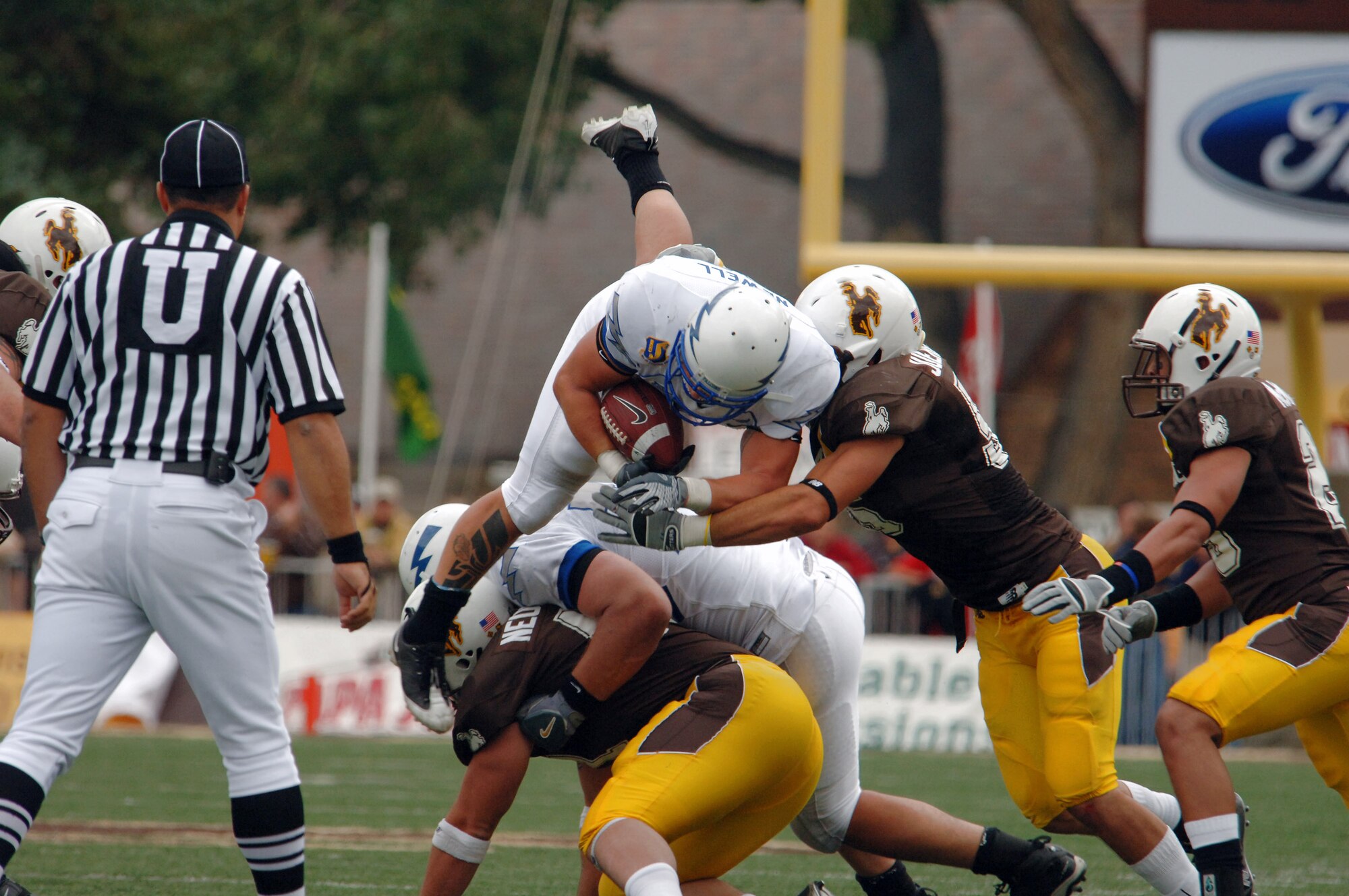 U.S. Air Force Academy fullback Todd Newell dives over the top of Wyoming defenders for a first down Sept. 6 in Laramie, Wyo. Newell made eight carries for 23 yards and scored the game's final touchdown, in the Falcons' 23-3 win over Wyoming. (U.S. Air Force photo/John Van Winkle) 
