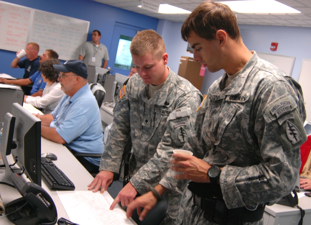 Two soldiers from the Florida Army National Guard's 3rd Battalion, 20th Special Forces Group, pinpoint low-lying areas of Key West, Fla., affected by storm surge from Hurricane Ike, during a morning briefing in the Key West Emergency Operations Center, Sept. 9, 2008. U.S. Air Force photo by Tech. Sgt. Thomas Kielbasa, Florida National Guard