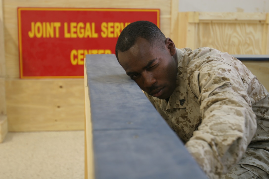 Cpl. John Turpin, combat engineer with Marine Wing Support Squadron 172, Marine Wing Support Group 37, 3rd Marine Aircraft Wing (Forward) checks the alignment of the jurors’ box Sept. 9. Turpin led a group of engineers in the courtroom project, which included designing the jurors’ box, witness stands and a judge’s bench.