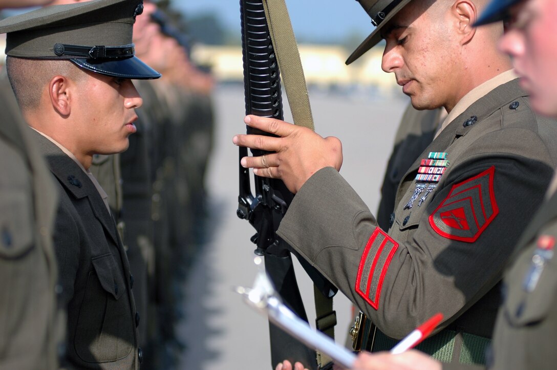 Staff Sgt. Nelson A. Coburn, drill instructor, Company C, inspects Pvt. Steven Strickland, Platoon 1016, Company A, during the battalion commander’s inspection Tuesday morning.