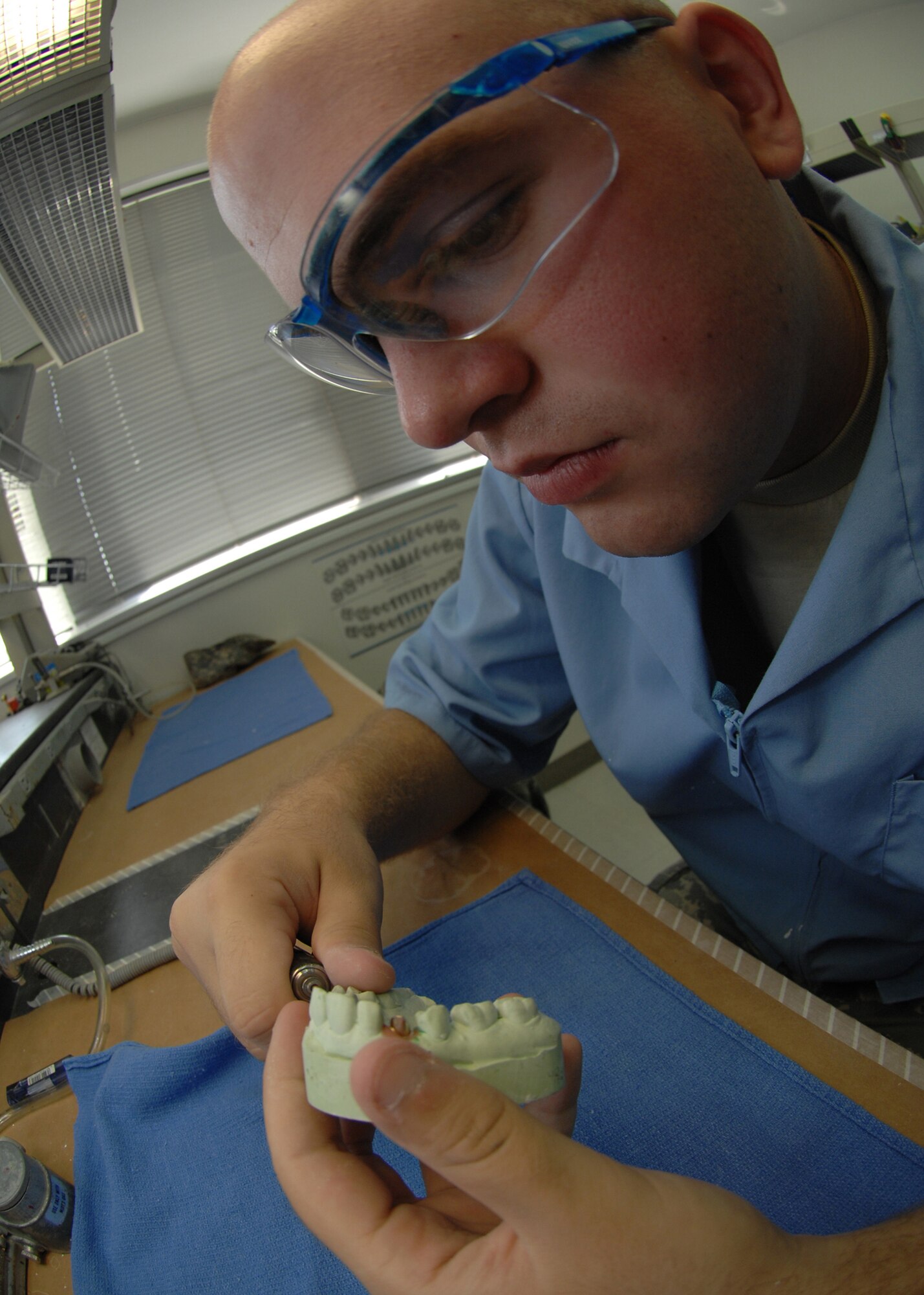 YOKOTA AIR BASE, Japan - Airman 1st Class Sherburne Raymond, from the 374th Dental Squadron, cuts into a mold of a patient's teeth at the dental laboratory on Sept. 10.  The dental lab makes dentures, veneers, crowns, bridges, mouthguards and more.  (U.S. Air Force photo by Airman 1st Class Jonathan Fowler)
