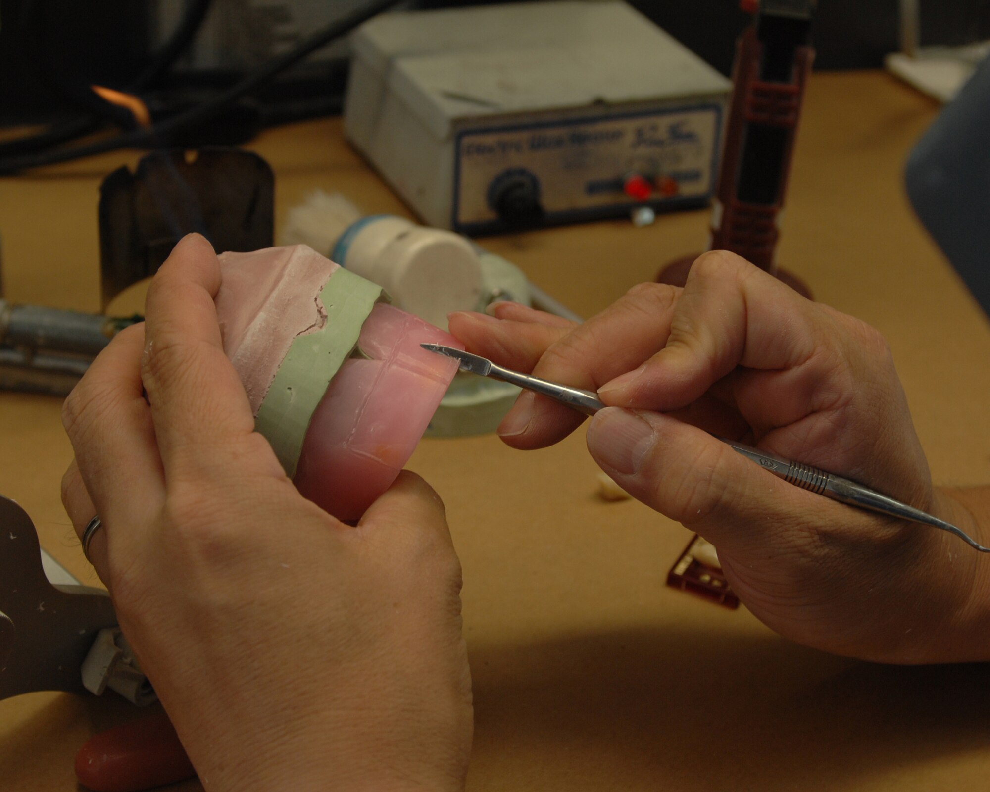 YOKOTA AIR BASE, Japan - Fujio Ishikawa, from the 374th Dental Squadron, cuts into a new set of dentures he is making at the dental laboratory on Sept. 10.  The dental lab makes dentures, veneers, crowns, bridges, mouthguards and more.  (U.S. Air Force photo by Airman 1st Class Jonathan Fowler)