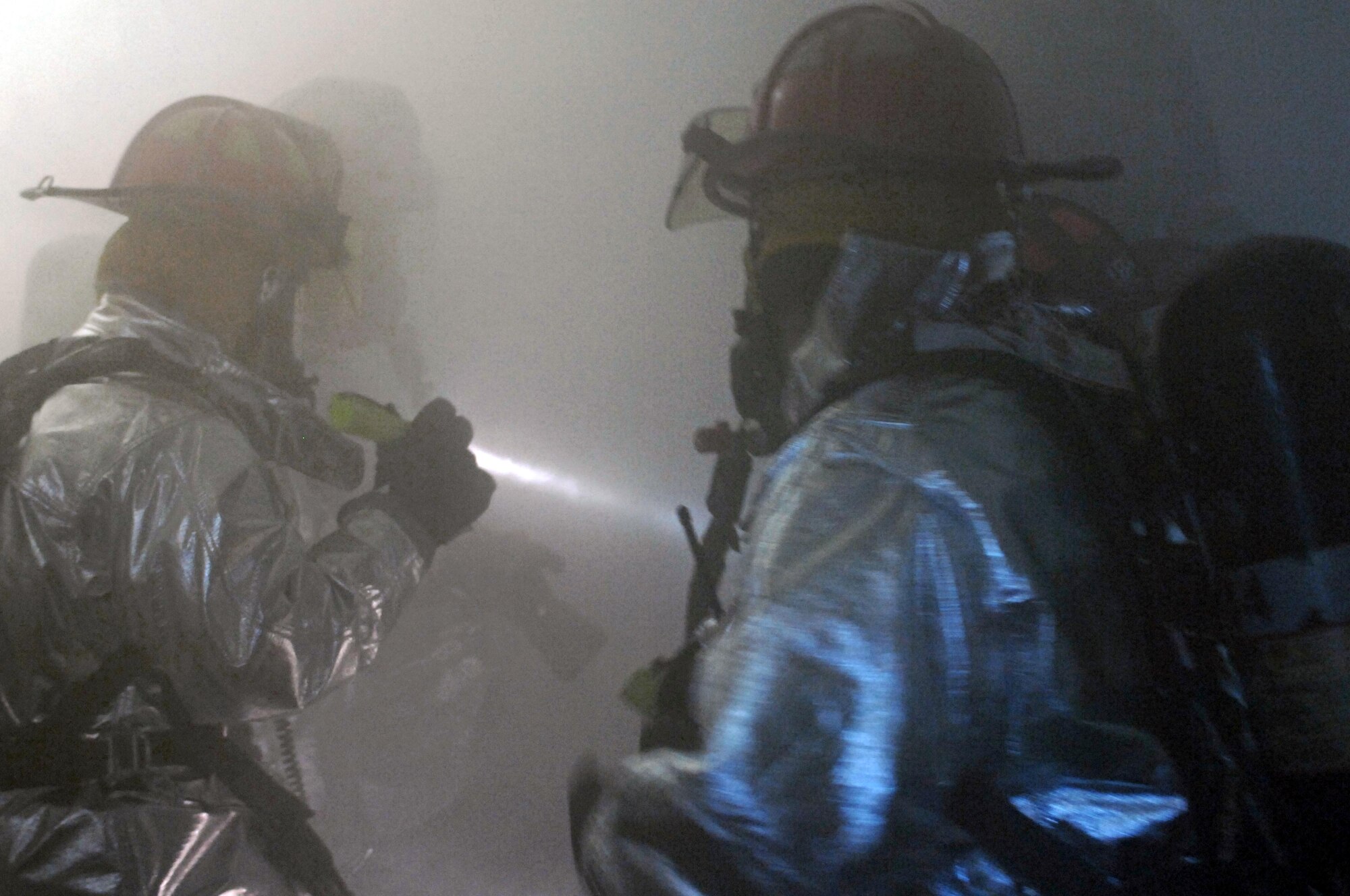 Fire fighters from the 28th Civil Engineer Squadron inspect the Rushmore Inn dormitory during an anti-terrorism exercise here Sept. 10. After the simulated explosion, exercise participants were challenged with various medical and security scenarios. (U.S. Air Force photo by Airman Corey Hook)