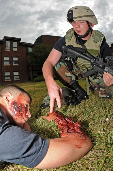 Airman 1st Class Jeffrey Gordon, 28th Security Forces Squadron police officer, checks  for possible head injury while administering Self-Aid and Buddy Care to Senior Airman Charles Stiles during an anti-terrorism force protection exercise on Sept. 10. Airman stiles simulated symptoms of burns and imbedded shrapnel suffered from an explosion. (U.S. Air Force photo/Senior Airman Marc I. Lane)
