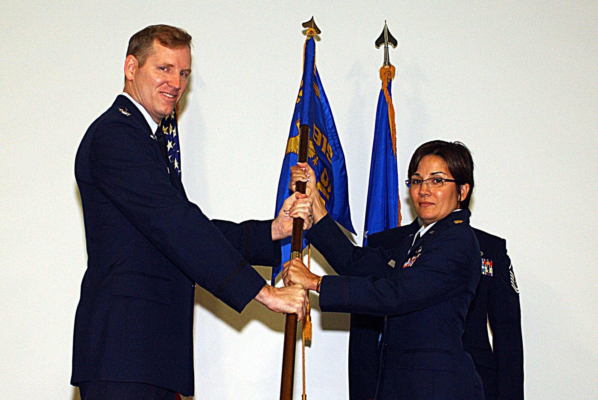 Col. Gary Nelson, 919th Mission Support Group commander, passes the 919th Services Flight guidon to the new flight commander, Maj. Grisel Mundo Sept. 6. (U.S. Air Force Photo\Master Sgt. Ricardo Clifton)                     