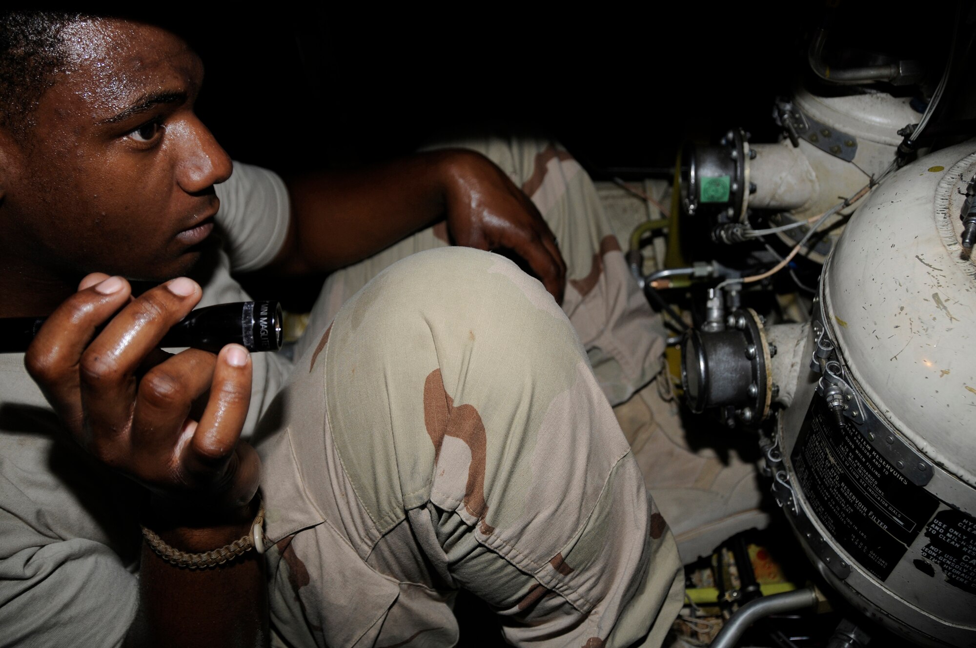 Petty Officer 3rd Class Davin Montgomery, aviation structural mechanic, uses a flashlight to check the hydraulic service center for hydraulic fluid leaks Sept. 9, 2008, at an undisclosed air base in Southwest Asia. The P-3 aircraft provides surveillance of the battlespace, either at sea or over land. Its long range and long loiter time have proved invaluable assets during Operations Iraqi and Enduring Freedom as it can view the battlespace and instantaneously provide that information to ground troops, especially U.S. Marines. Petty Officer Montgomery, a native of Chicago, Ill., is deployed from Naval Air Station Whidbey Island, Wash. (U.S. Air Force photo by Staff Sgt. Darnell T. Cannady/Released)