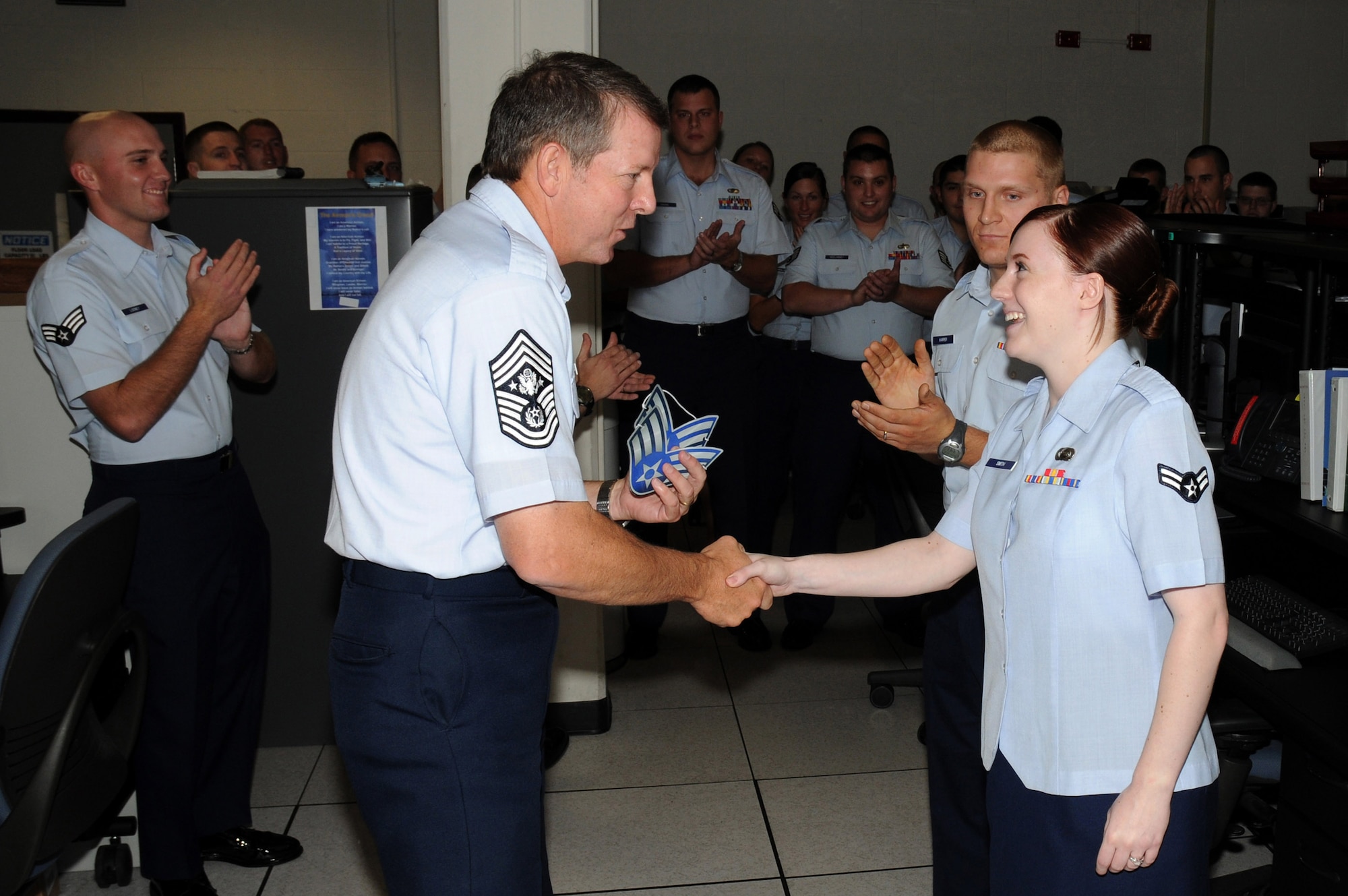 Chief Master Sergeant of the Air Force Rodney J. McKinley presents Airman 1st Class Lindsay Smith with a set of senior airman stripes during his visit to the National Air and Space Intelligence Center Sept. 8 at Wright-Patterson Air Force Base, Ohio. Airman Smith was awarded her stripes as a below-the-zone selectee. During his visit, the chief visited with enlisted, officer and civilian employees and answered questions from Airmen. He is the 15th chief master sergeant of the Air Force. (U.S. Air Force photo/Staff Sgt Joshua Strang) 

