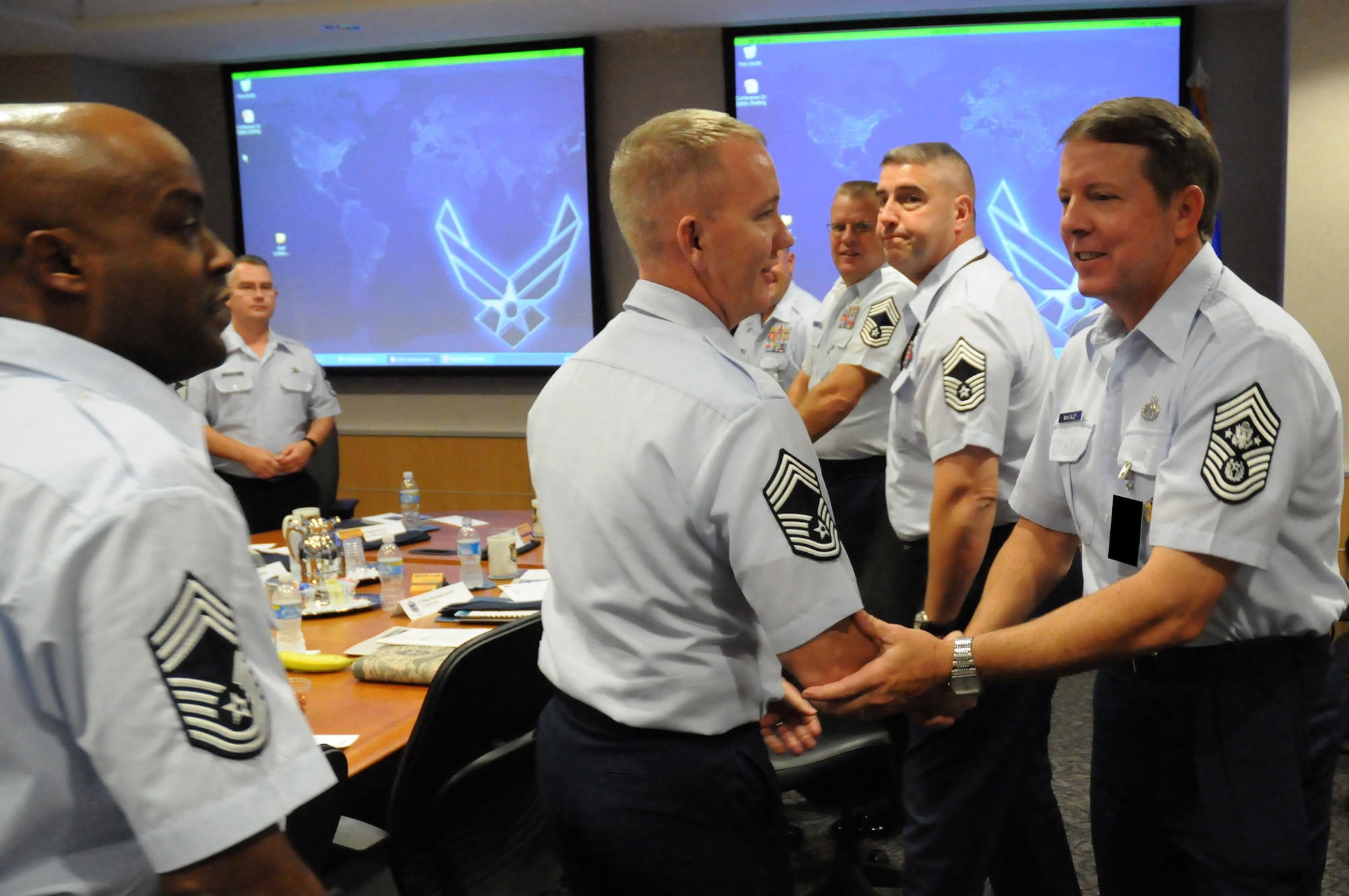 Chief Master Sgt. of the Air Force Rodney J. McKinley greets Chief Master Sgt. Christopher Hood and other chief master sergeants at the National Air and Space Intelligence Center during his visit Sept. 8 at Wright-Patterson Air Force Base, Ohio. During his visit, the chief visited with enlisted, officer and civilian employees and answered questions from Airmen. He is the 15th chief master sergeant of the Air Force. (U.S. Air Force photo illustration/Staff Sgt. Joshua Strang) 
