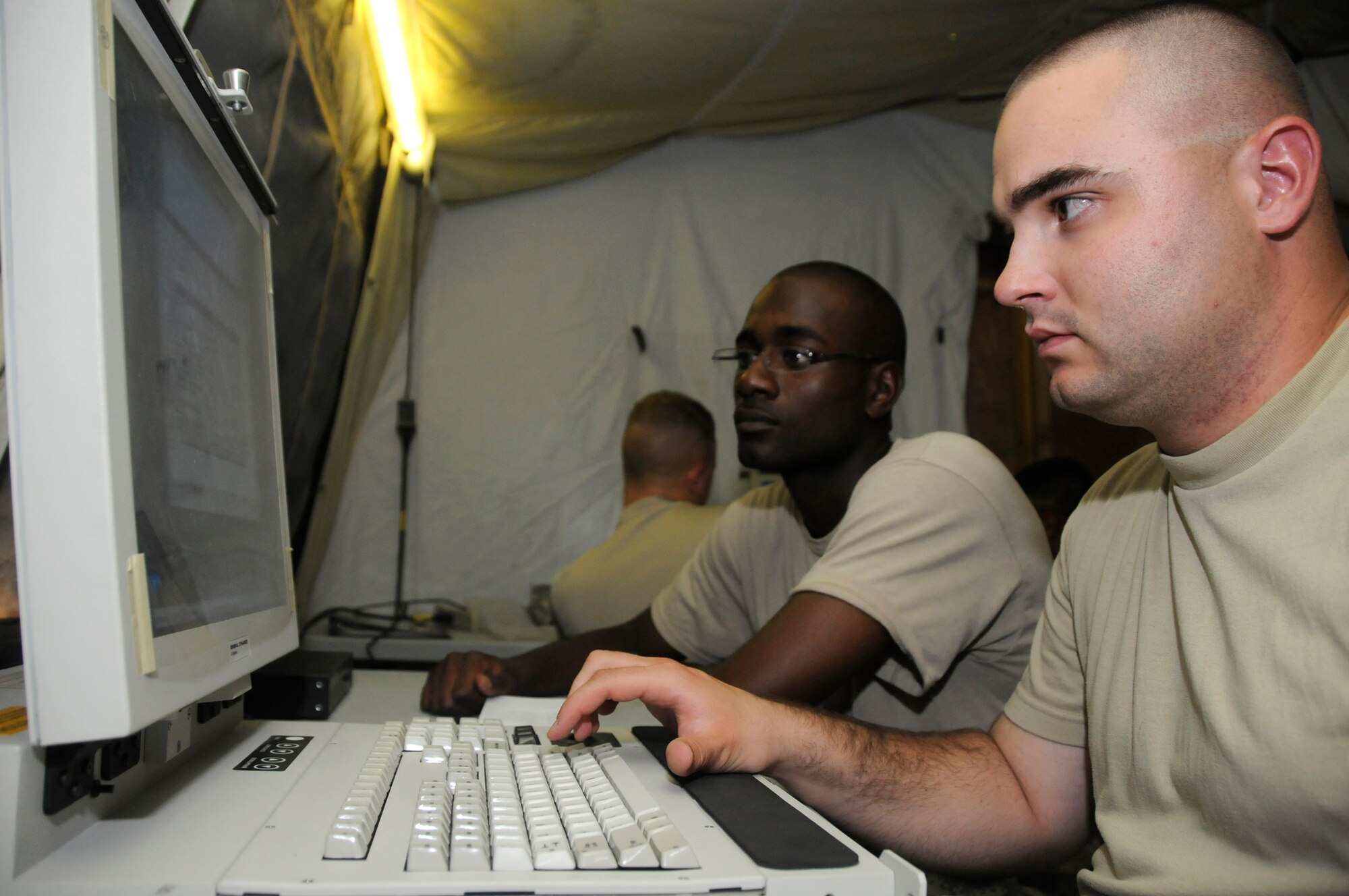 Spc. Wayne Landry (front) and Sgt. Eric Simpson (back), both early system warning operators assigned to Delta 2.43, review training guides and input data into the force operations battery command post so they can complete their post deployment build 6 upgrade training Sept. 8, 2008. The Army Patriot battery is responsible for providing missile defense at this undisclosed air base in Southwest Asia. Specialist Landry, a native of Frederick, Md., and Sergeant Simpson, a native of San Francisco, Calif., are both deployed from Fort Bliss, Texas, in support of Operations Iraqi Freedom, Enduring Freedom and Joint Task Force-Horn of Africa. (U.S. Air Force photo by Staff Sgt. Darnell T. Cannady/Released)